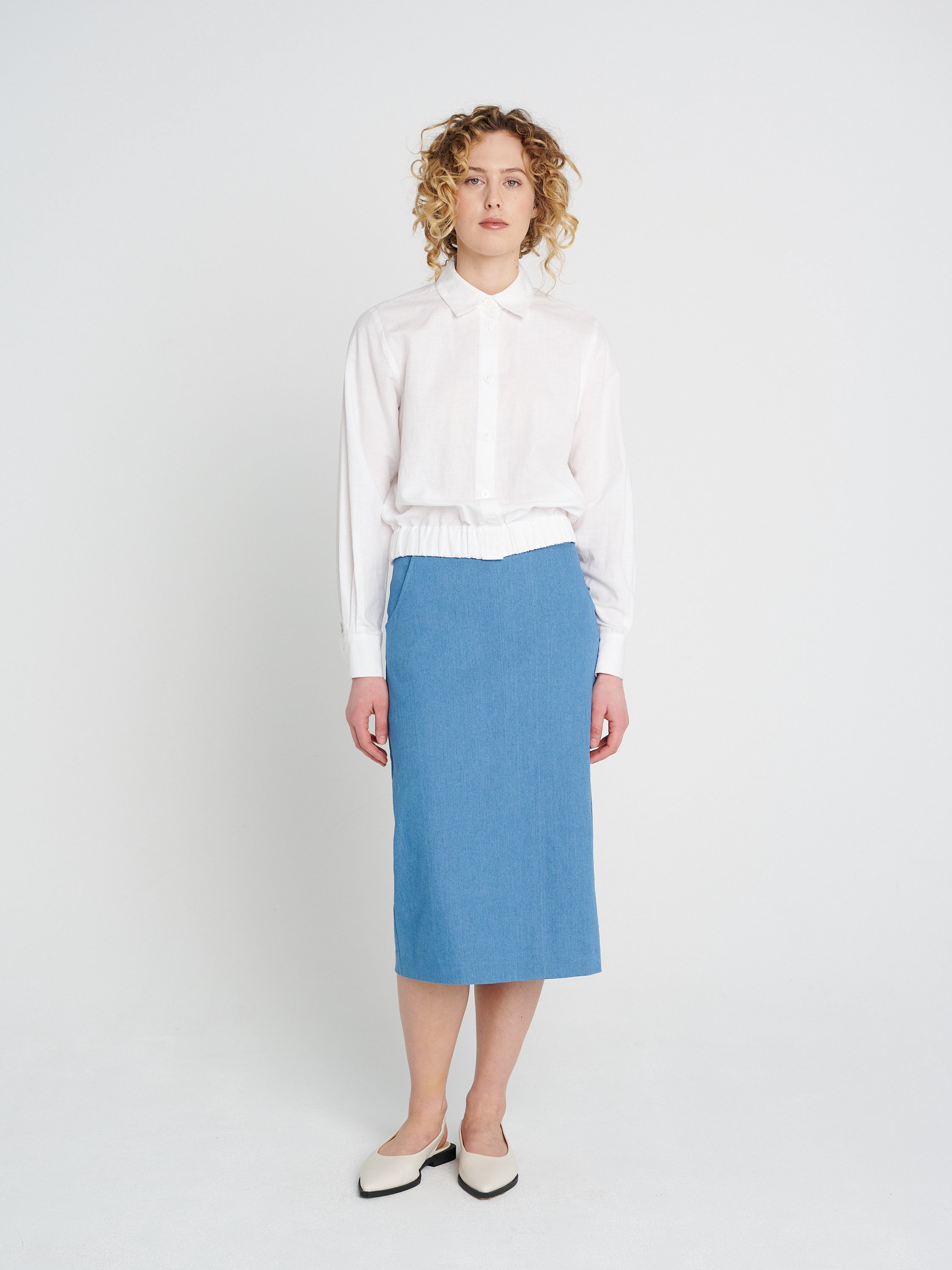 Weißes Leinenhemd im Blouson Stil mit weiten Ärmeln, Kragen und Knopfleiste.