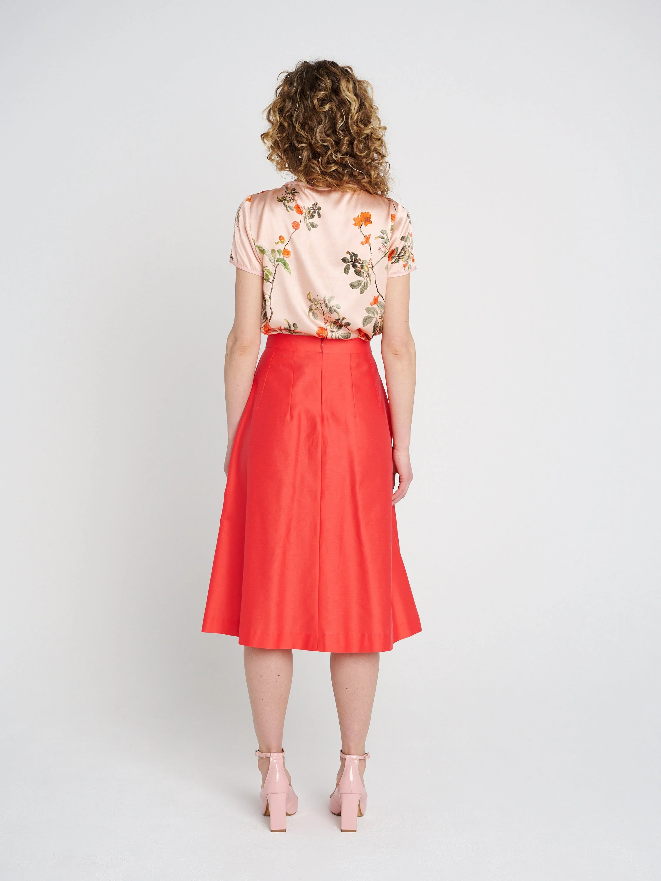 A-Liniger Sommerrock in orange-pink mit Taschen und Kellerfalten, halblang.