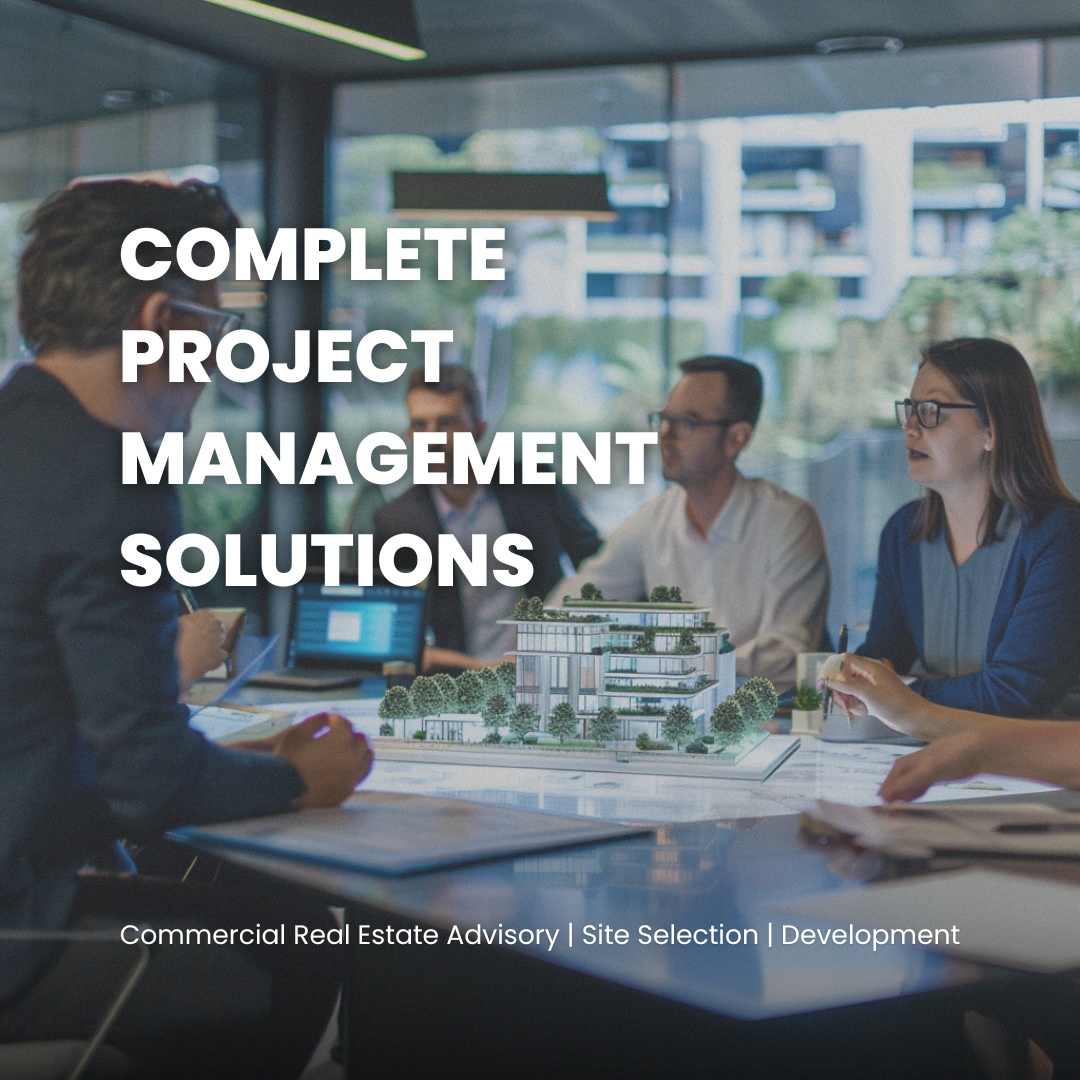 Business team having a meeting in a modern conference room with a scale model of a building and a cityscape view outside.
