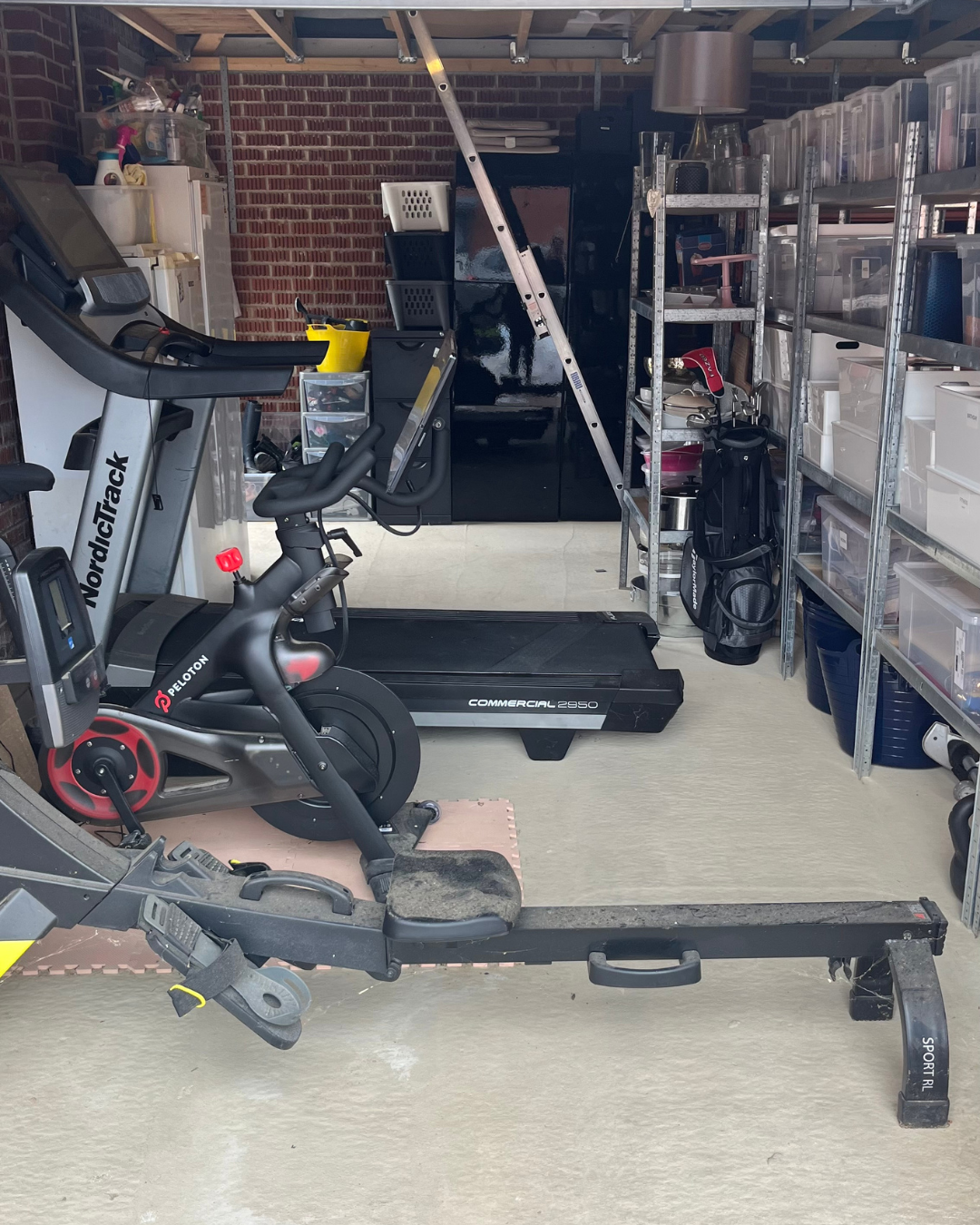 Home gym setup with a treadmill, an exercise bike, and weightlifting equipment in a garage with shelves and storage containers.