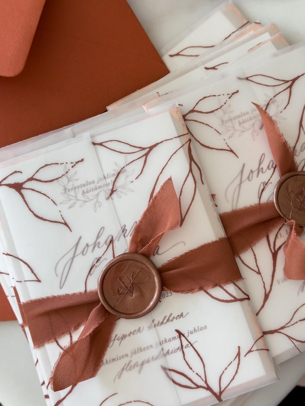 Syksyinen hääkutsu, terracotan sävyisellä silkkinauhalla ja monogrammisinetillä.