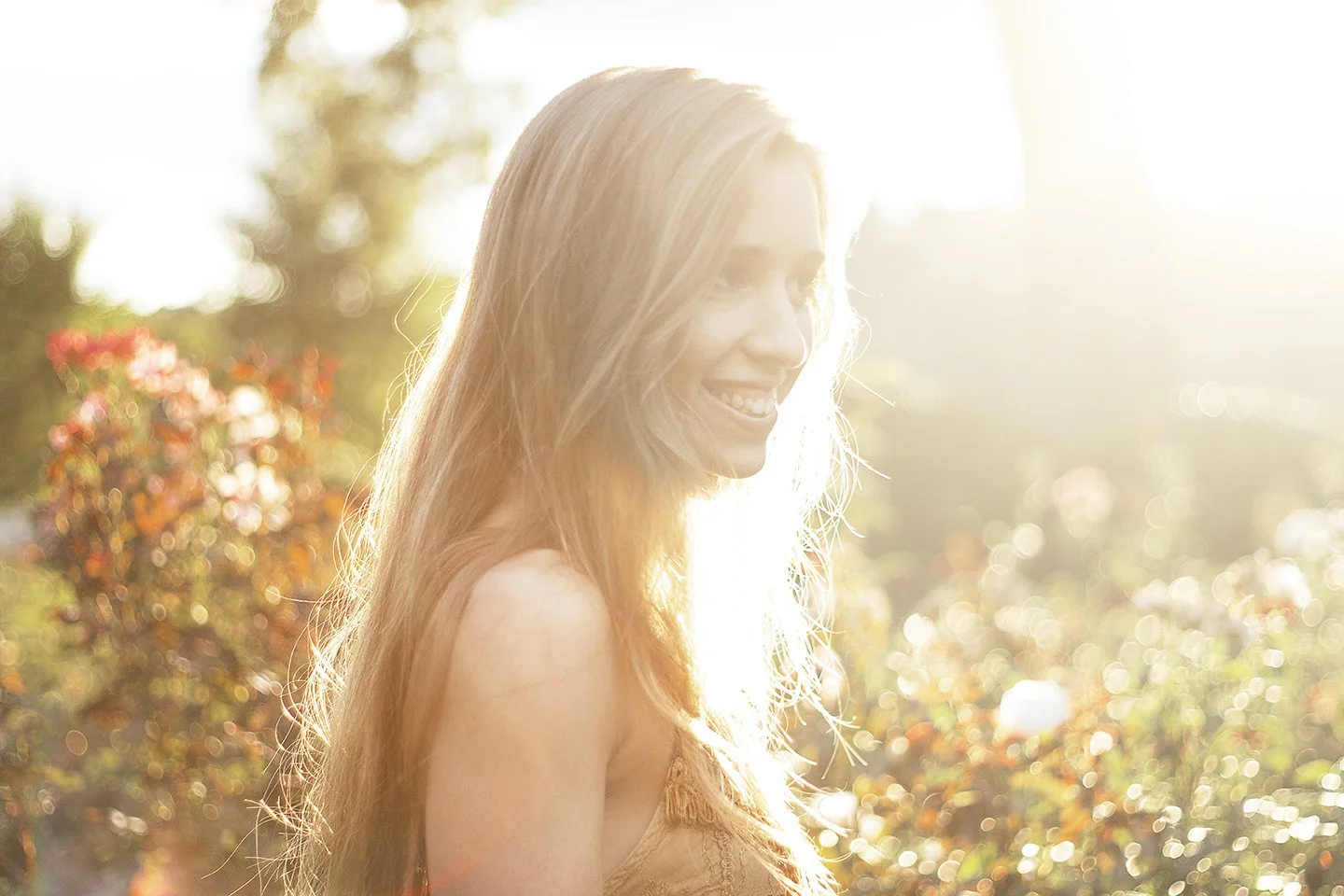 Sunny portrait of a beautiful blond in a garden