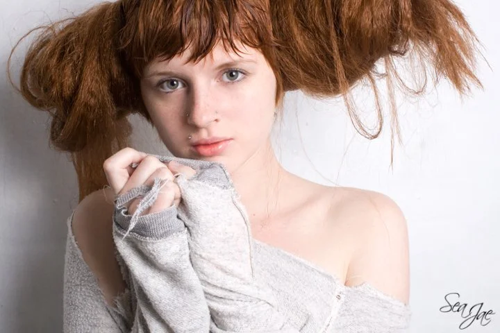 redheaded woman natural beauty messy buns ripped shirt