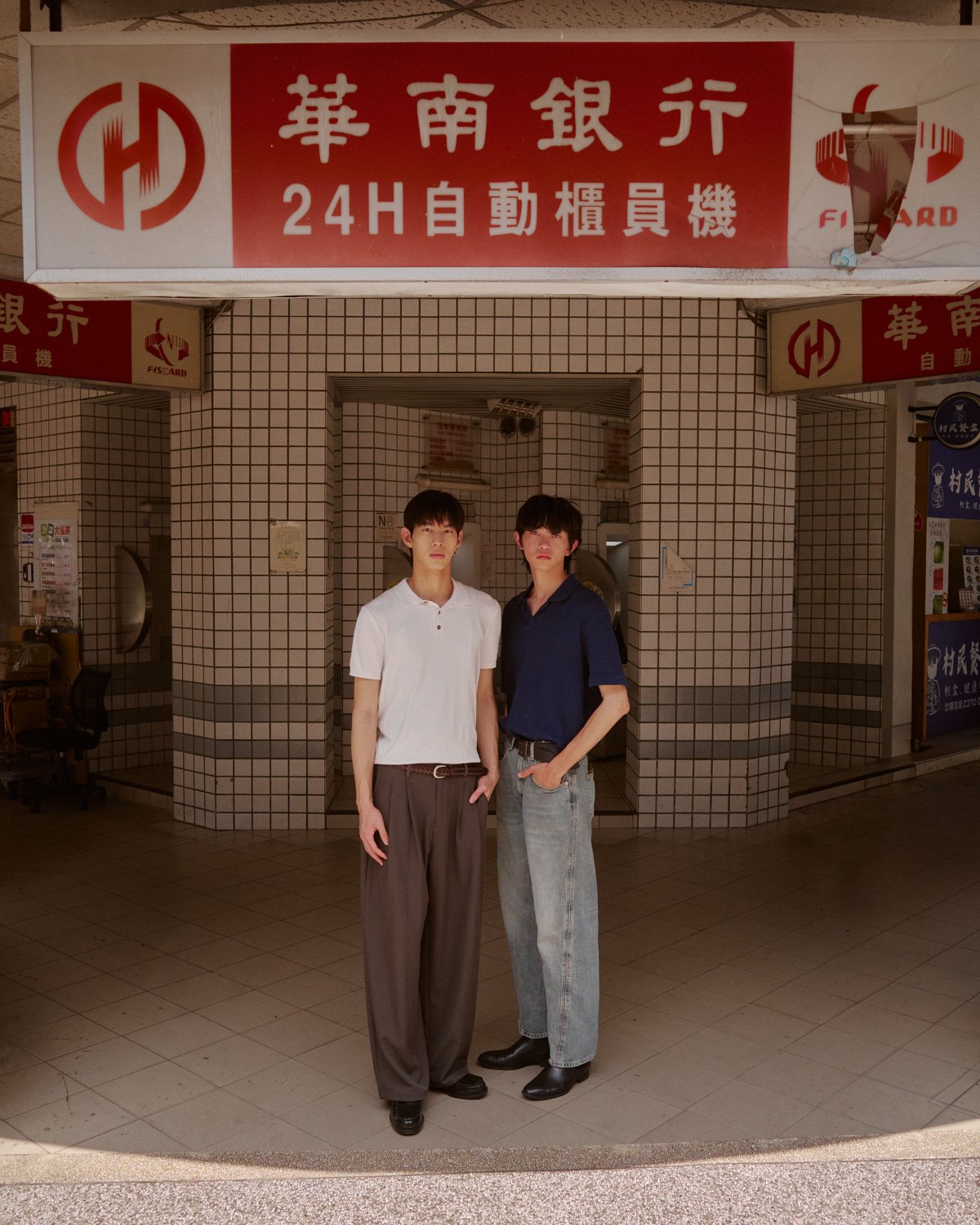 Fashion editorial featuring two male models in a Taipei bank entrance photographed by Pedro Márnez
