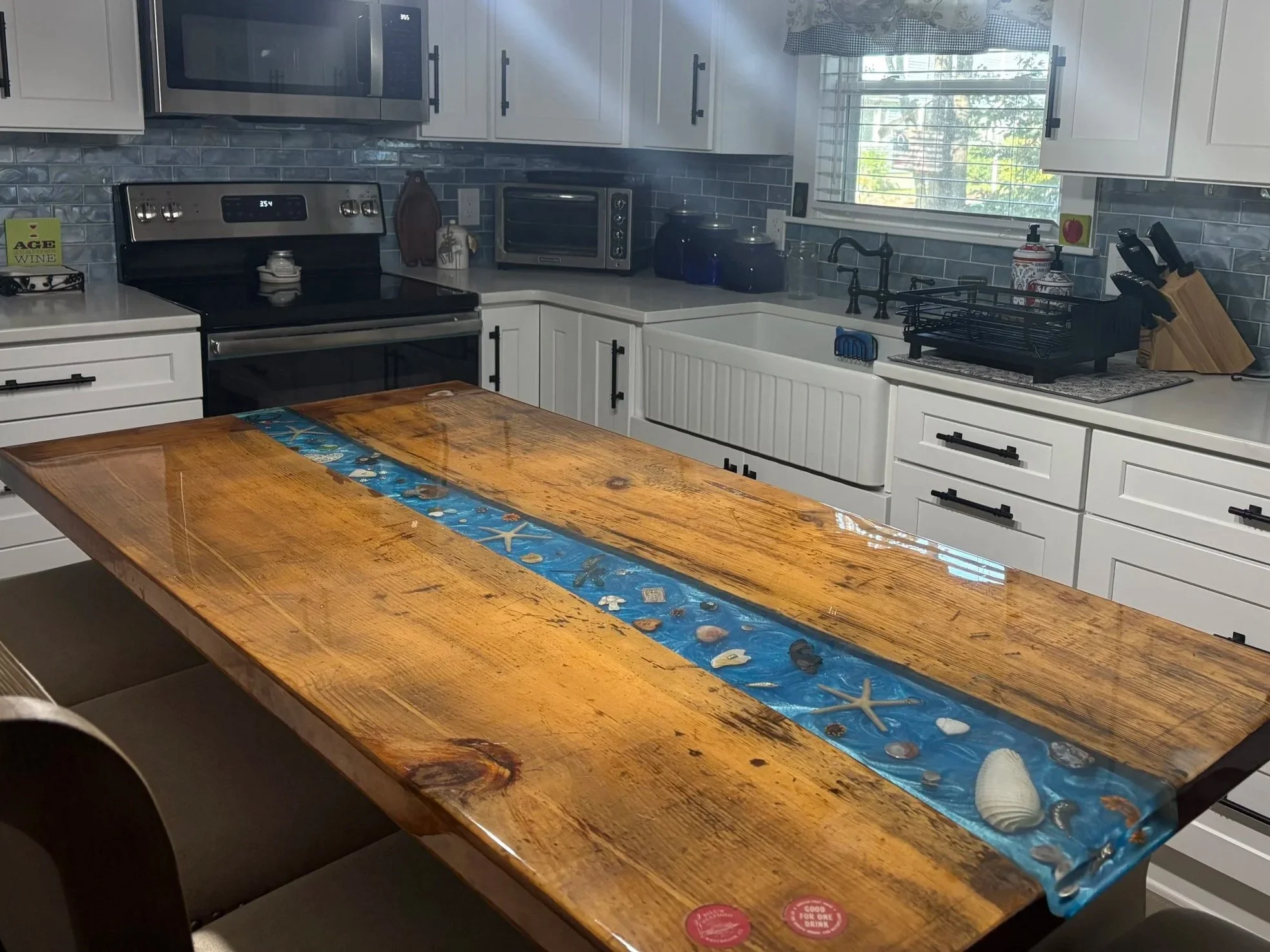 A custome kitchen island with a blue river featuring seashell and and other memorabilia chosen by the family it was made for