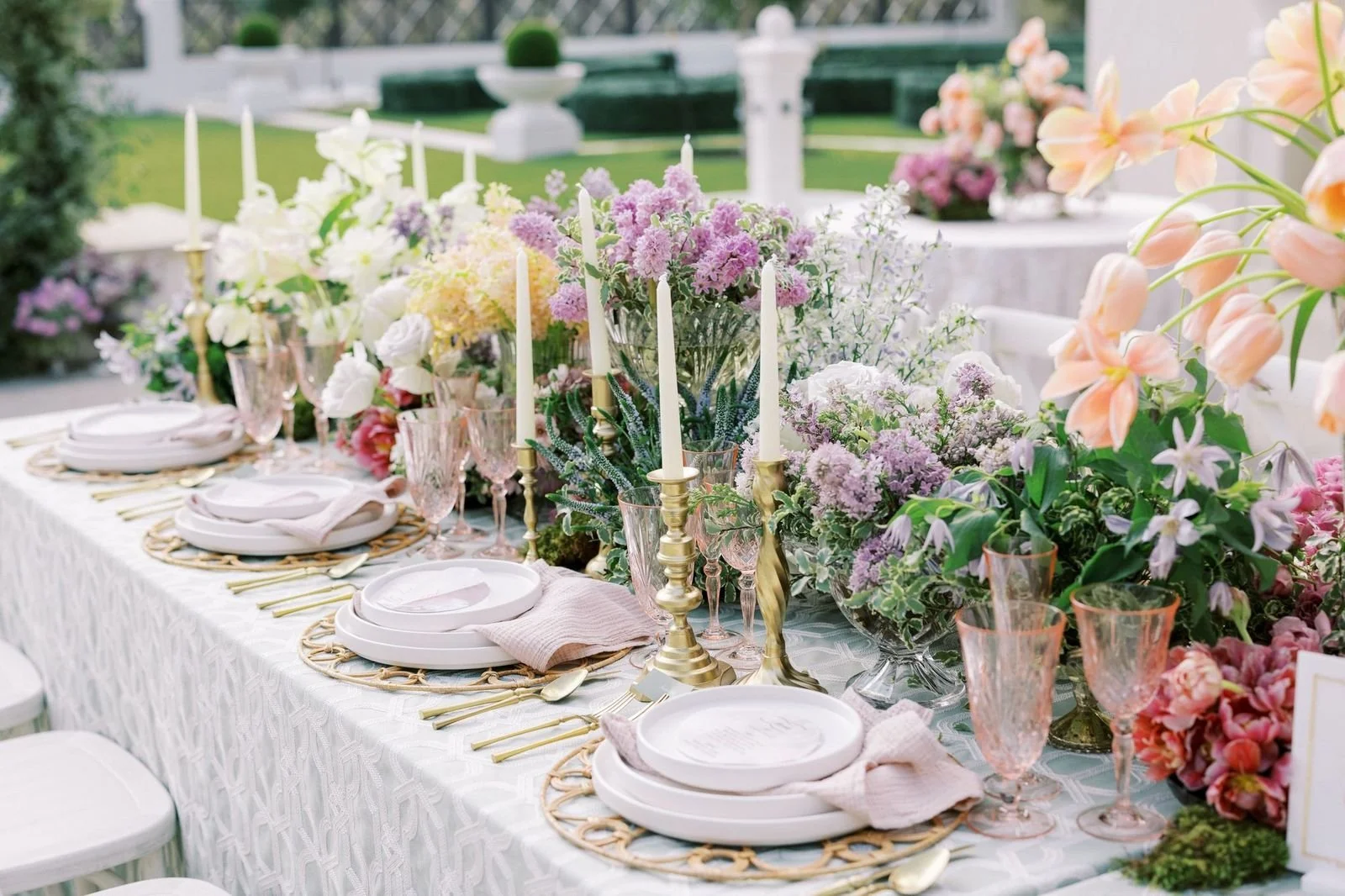 Romantic outdoor wedding reception tablescape featuring floral centerpieces, taper candles, and curated place settings. New Jersey Florist.