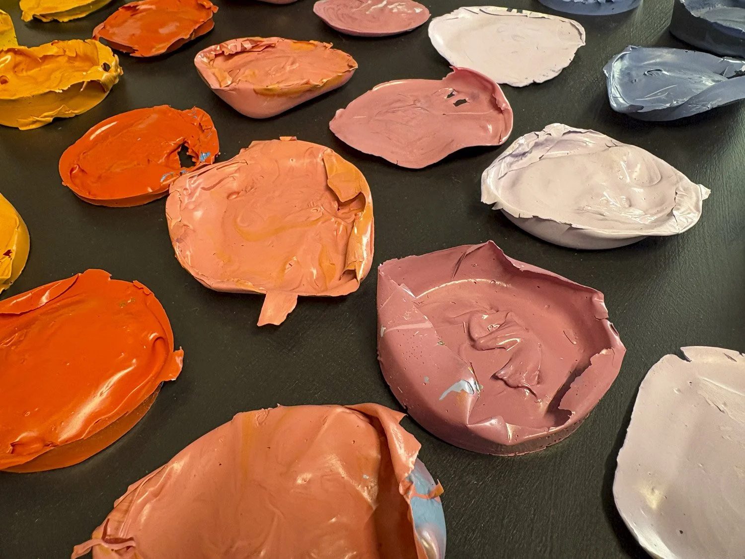 a selection of harmonically orange and peach colored dried paint arranged into a grid of carefully arranged colors.