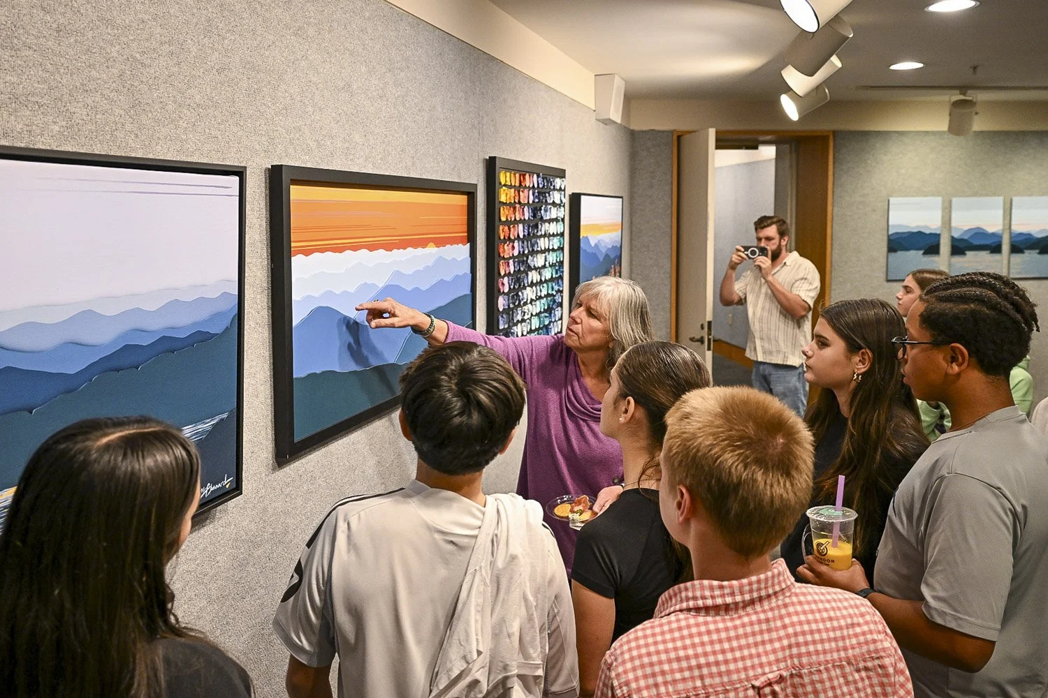 Mixed media landscape and abstract painter Cindy Chenard answering question about her artwork, at a gallery talk in Asheville, NC.