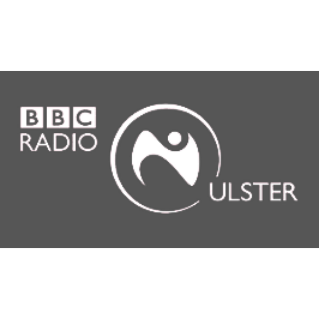 BBC Radio Ulster logo with gray background, white text, and a circular emblem