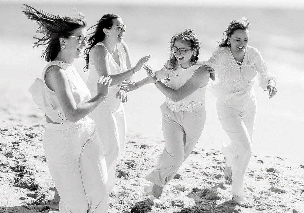Filles vêtues de blanc courant sur la plage riant