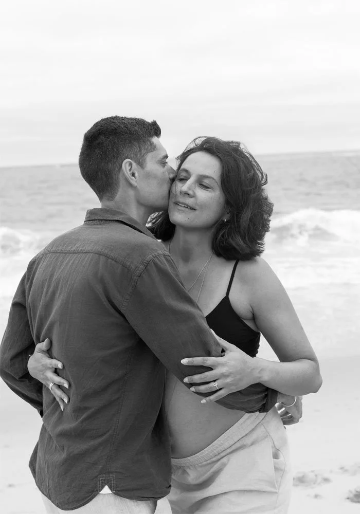 Couple enlacé tendrement lors d'une séance de grossesse sur une plage du Bassin d'Arcachon