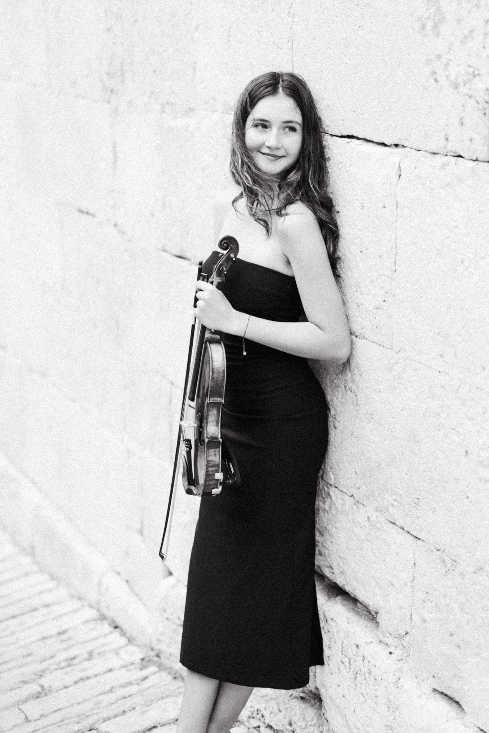 Black and white portrait of a violinist in a classical location.