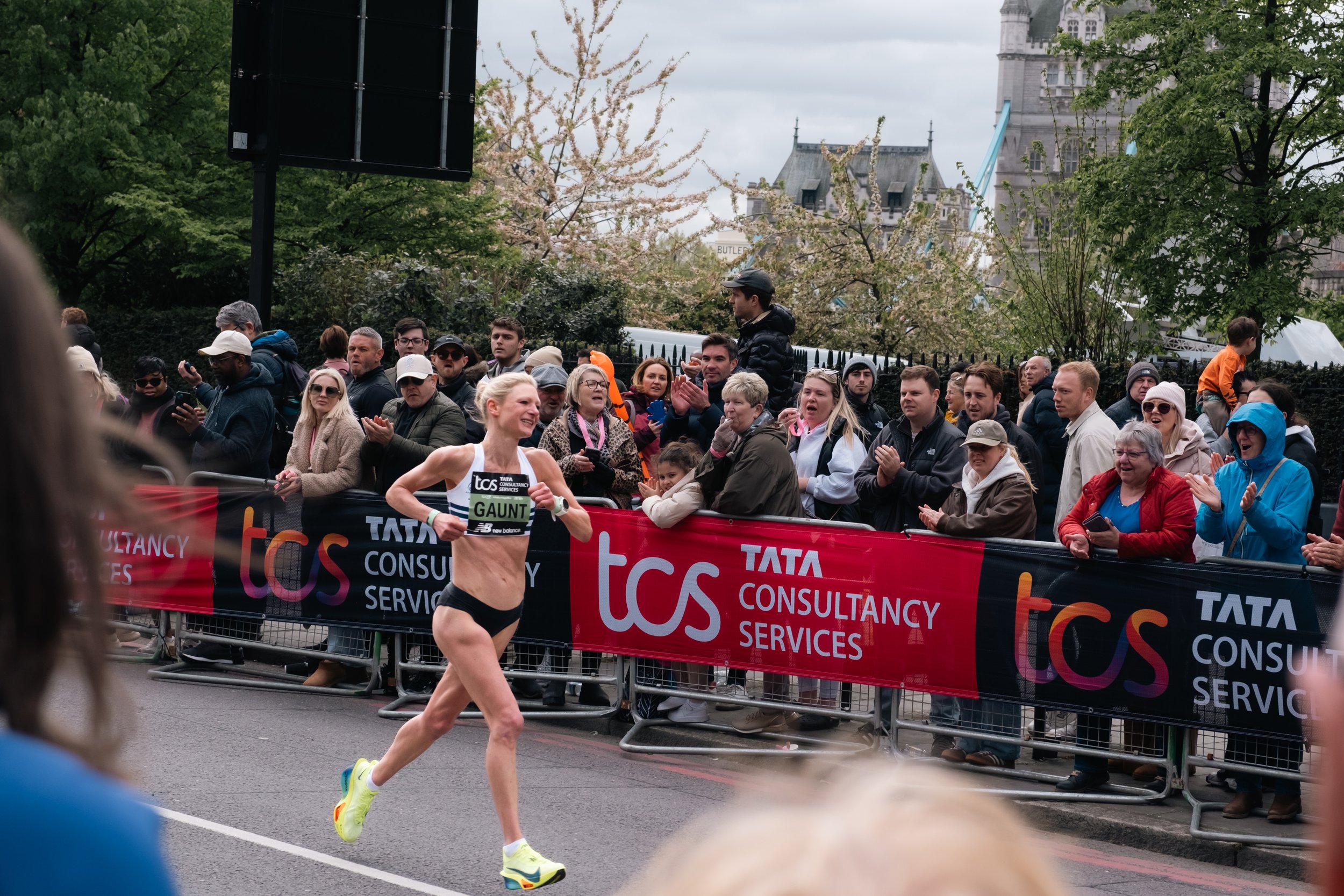 Close-up of a determined runner during the London Marathon with the city skyline in the background.