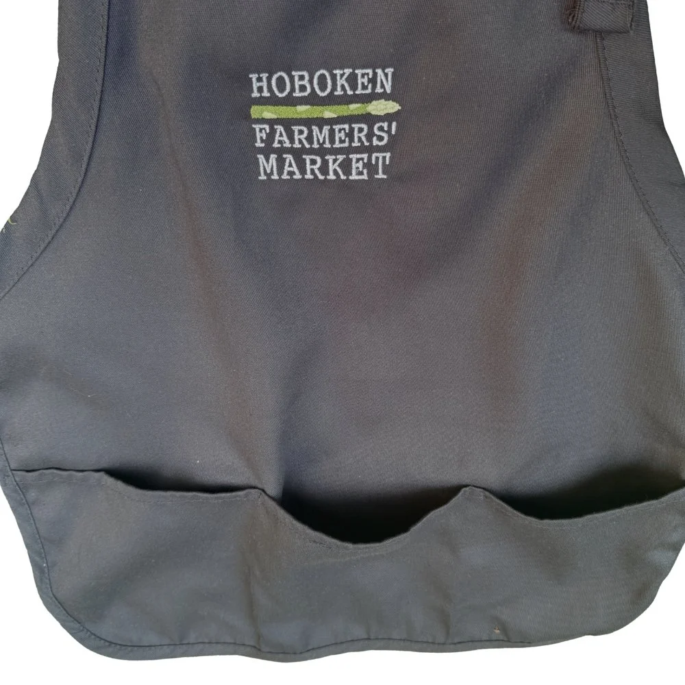 Detail of 3 pockets on the black Apron with embroidered Hoboken Farmers' Market logo