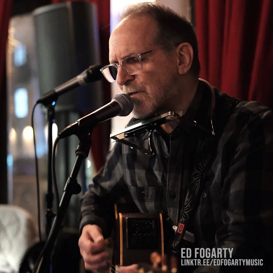 Photo of Ed Fogarty playing guitar & singing