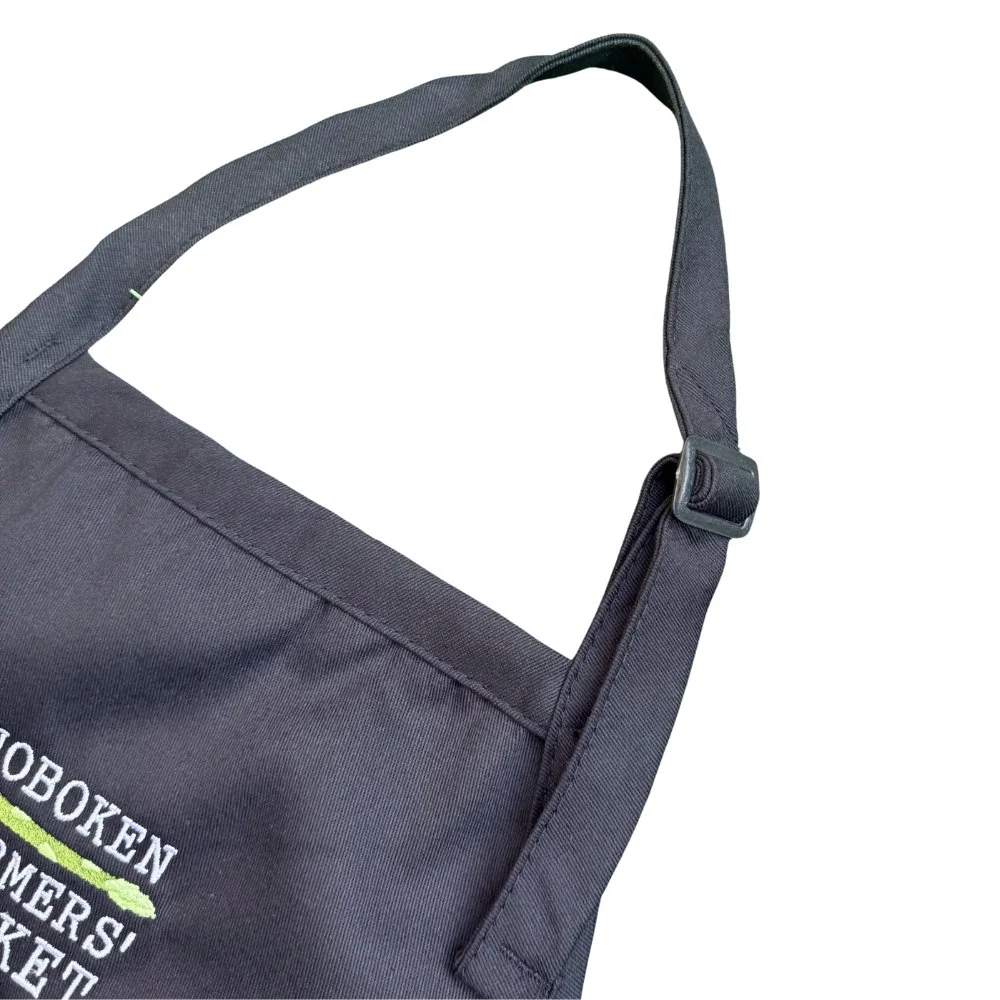 Detail of the adjustable neck strap on the black Apron with embroidered Hoboken Farmers' Market logo i