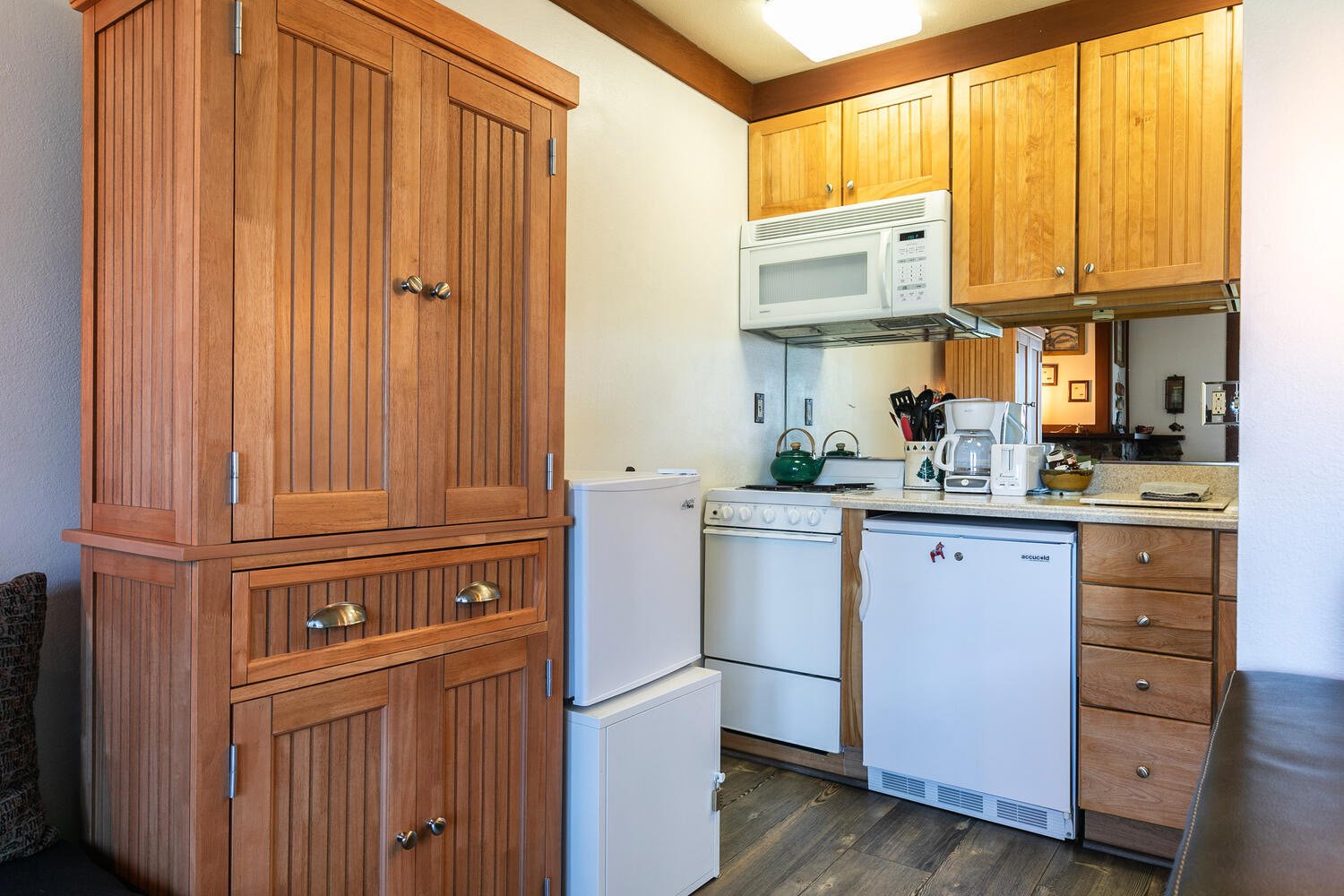 unit 3 kitchen with honey-colored cabinets and white appliances