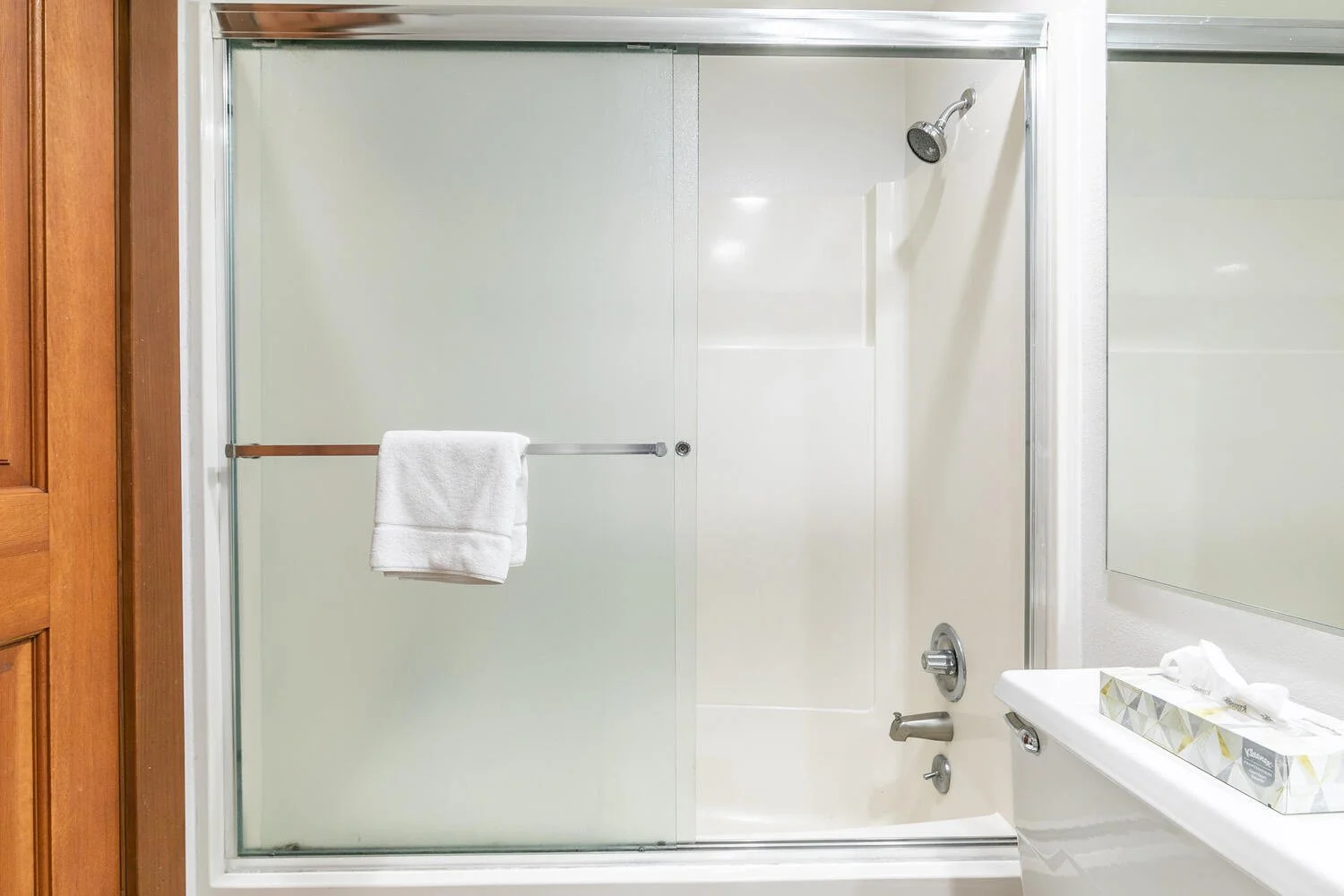 unit 3 view of bathtub/shower combo. frosted glass shower doors