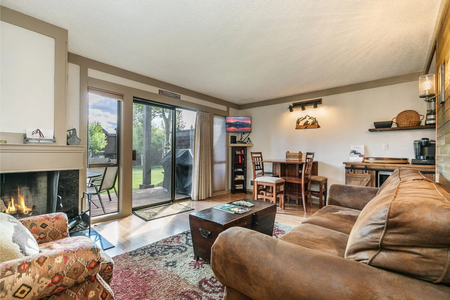unit 17 living room with slate blue walls. pine furniture, light gray couch and drapes