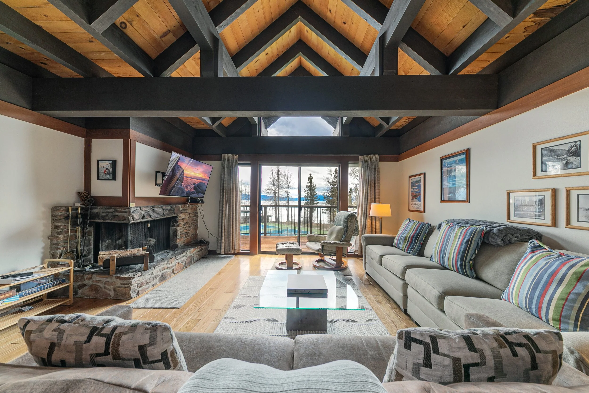 unit 6 living room with couch, striped pillows, view of tennis courts through sliding door