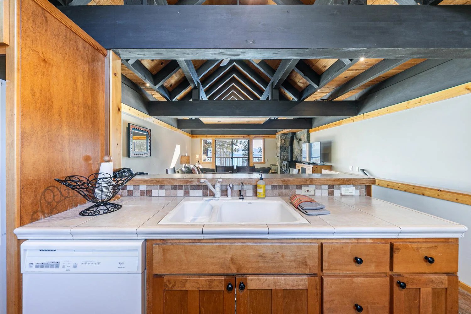 unit 7 kitchen with white tile countertops, pine cabinets, white appliances