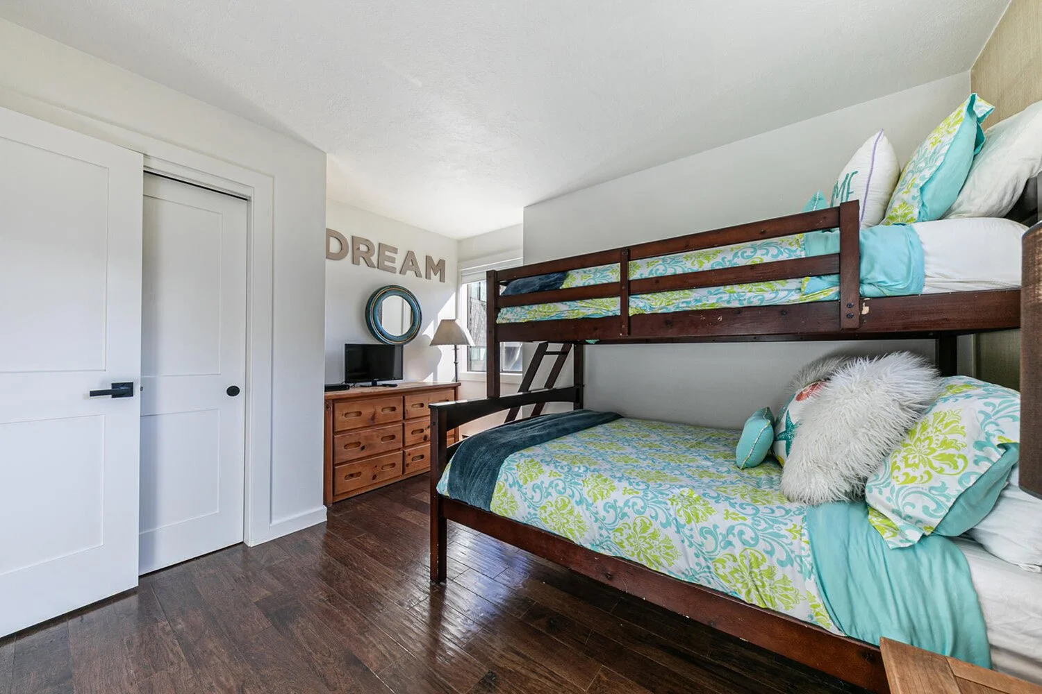 unit 41 second bedroom with bunk beds, large sign on wall that reads “dream”