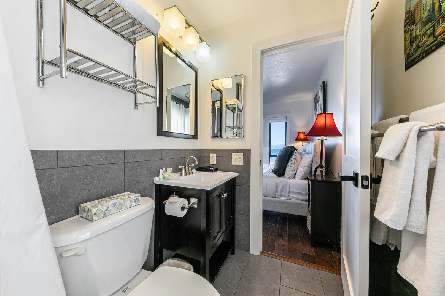 unit 41 main bathroom gray tile wainscoting, dark cabinet, white fixtures