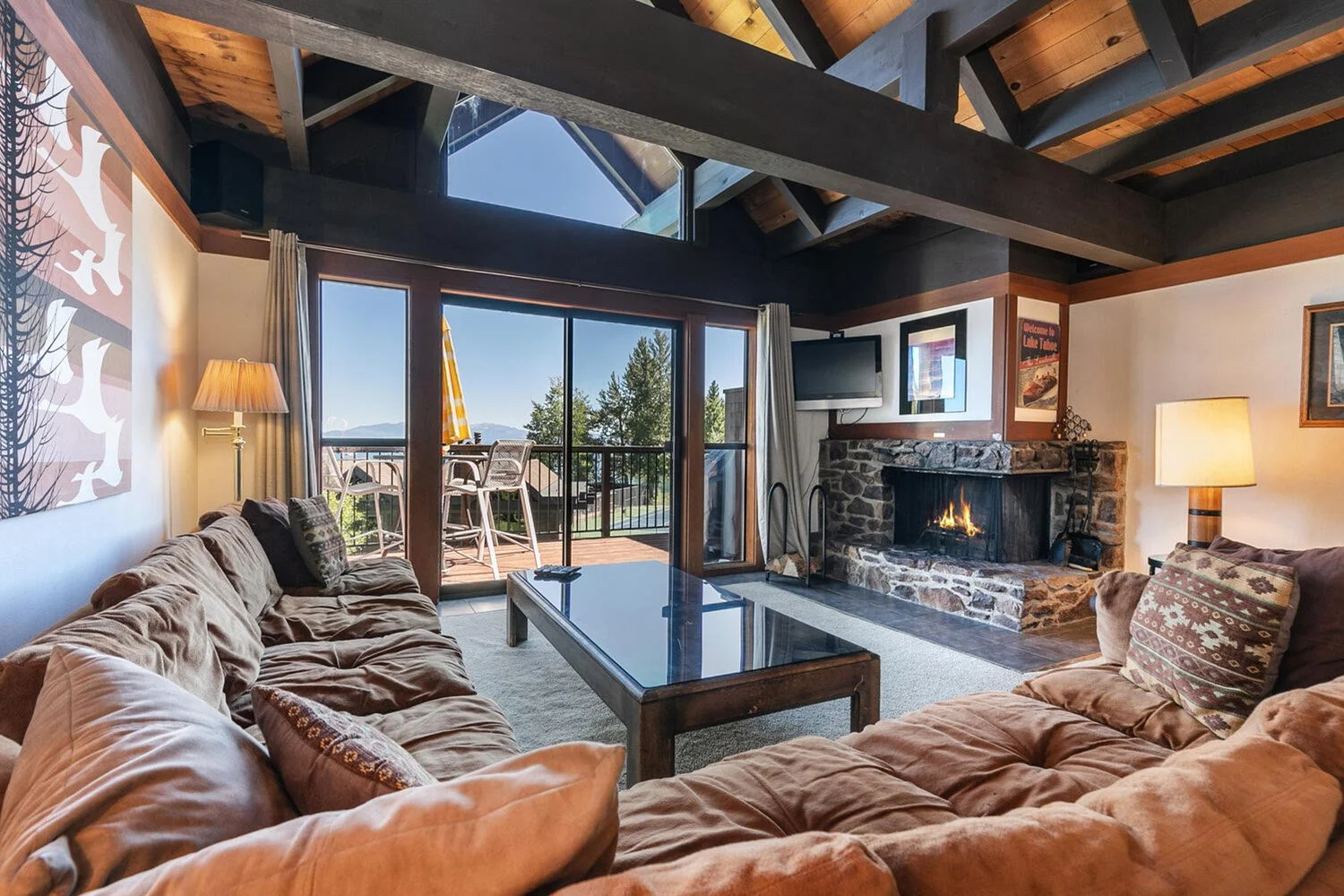 unit 15 living room showing fireplace, TV, and view off deck