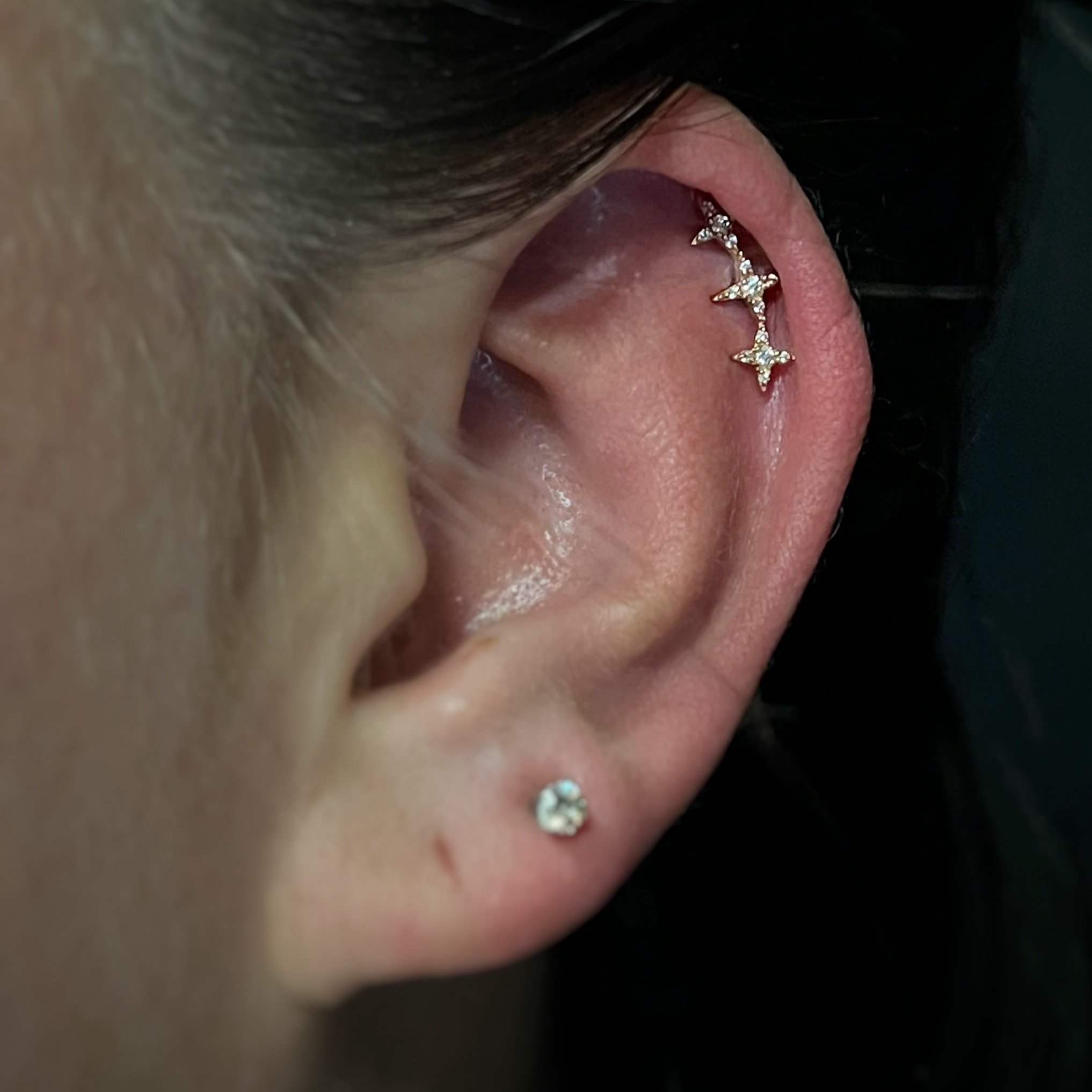 Close-up of a person with a yellow gold star-shaped earring