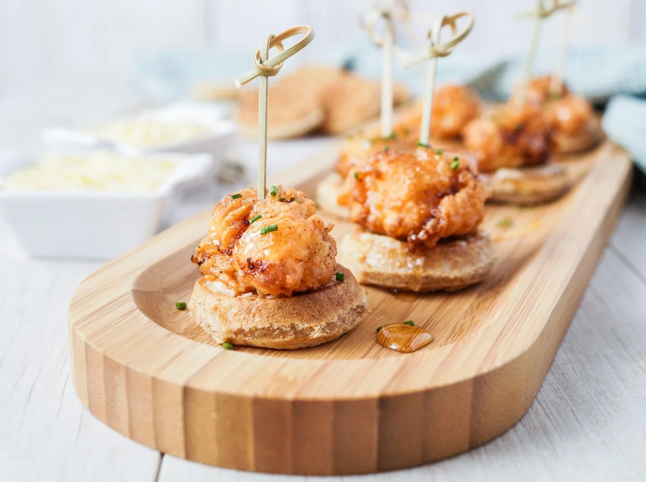 Fried chicken and waffles appetizers with a hot honey drizzle.