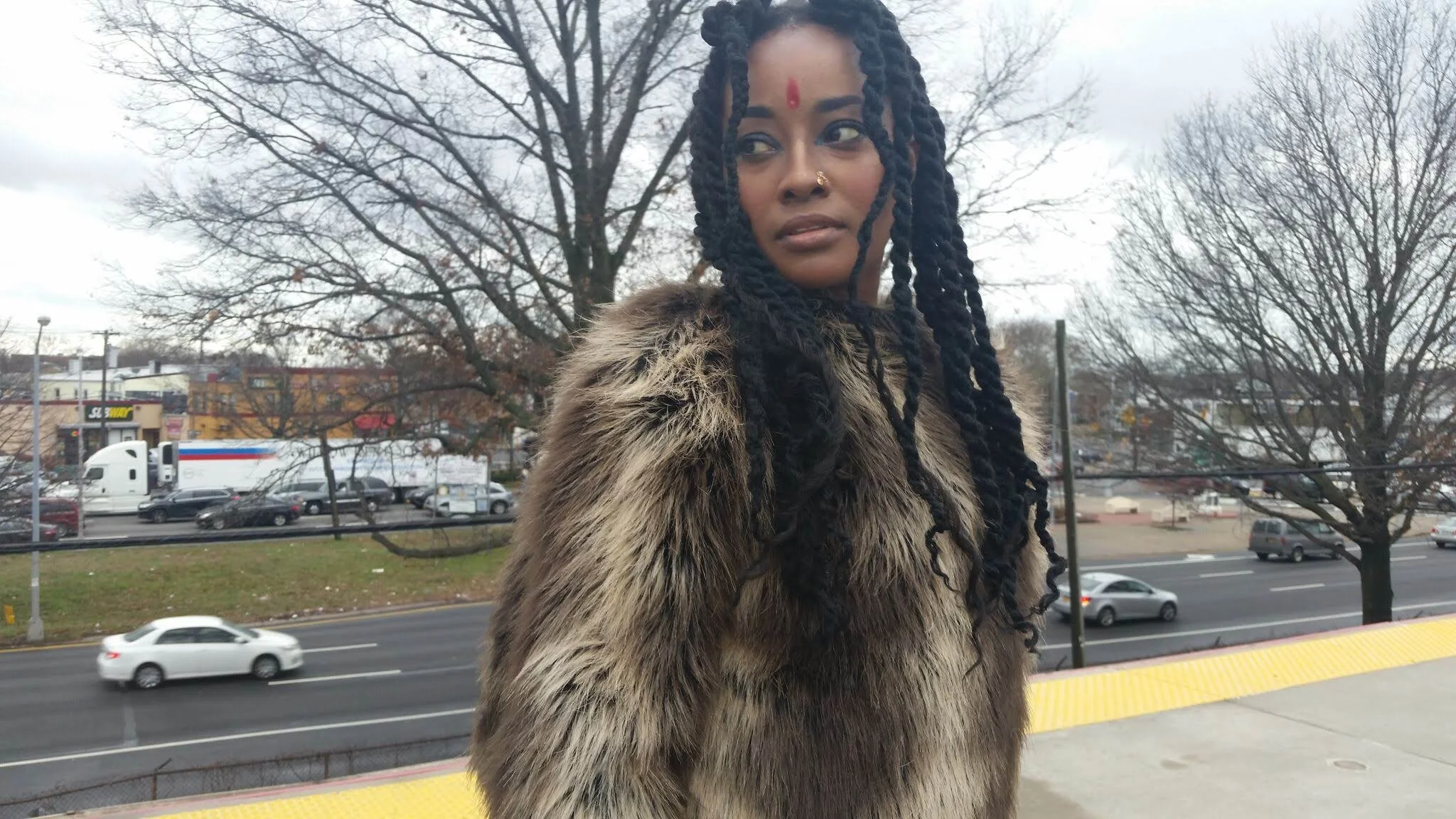 woman with long locs, fall, train station, fur jacket