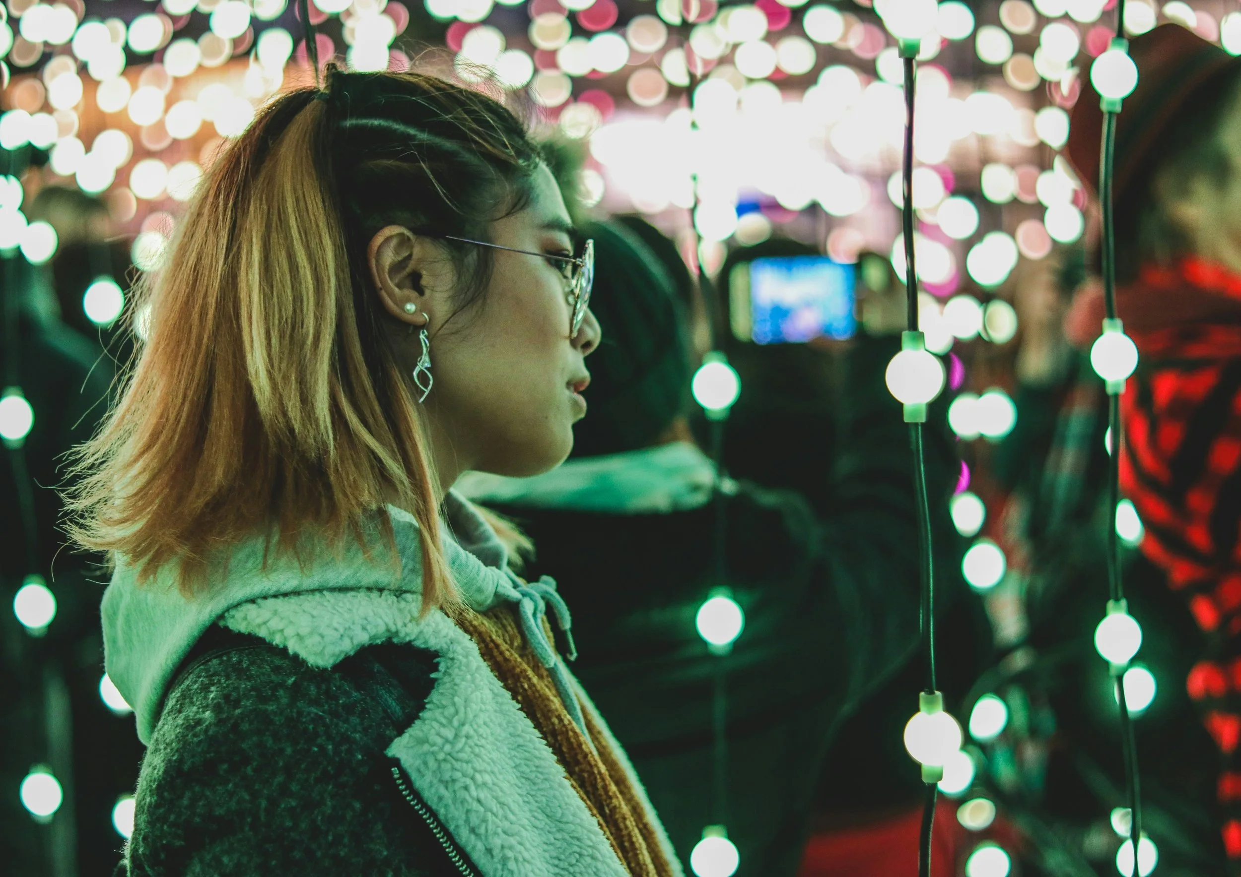 A woman surrounded by lights on strings. Represents marketing, research and insights industry. Estellar offers consulting, communications and coaching for digital transformation and people and culture development. 