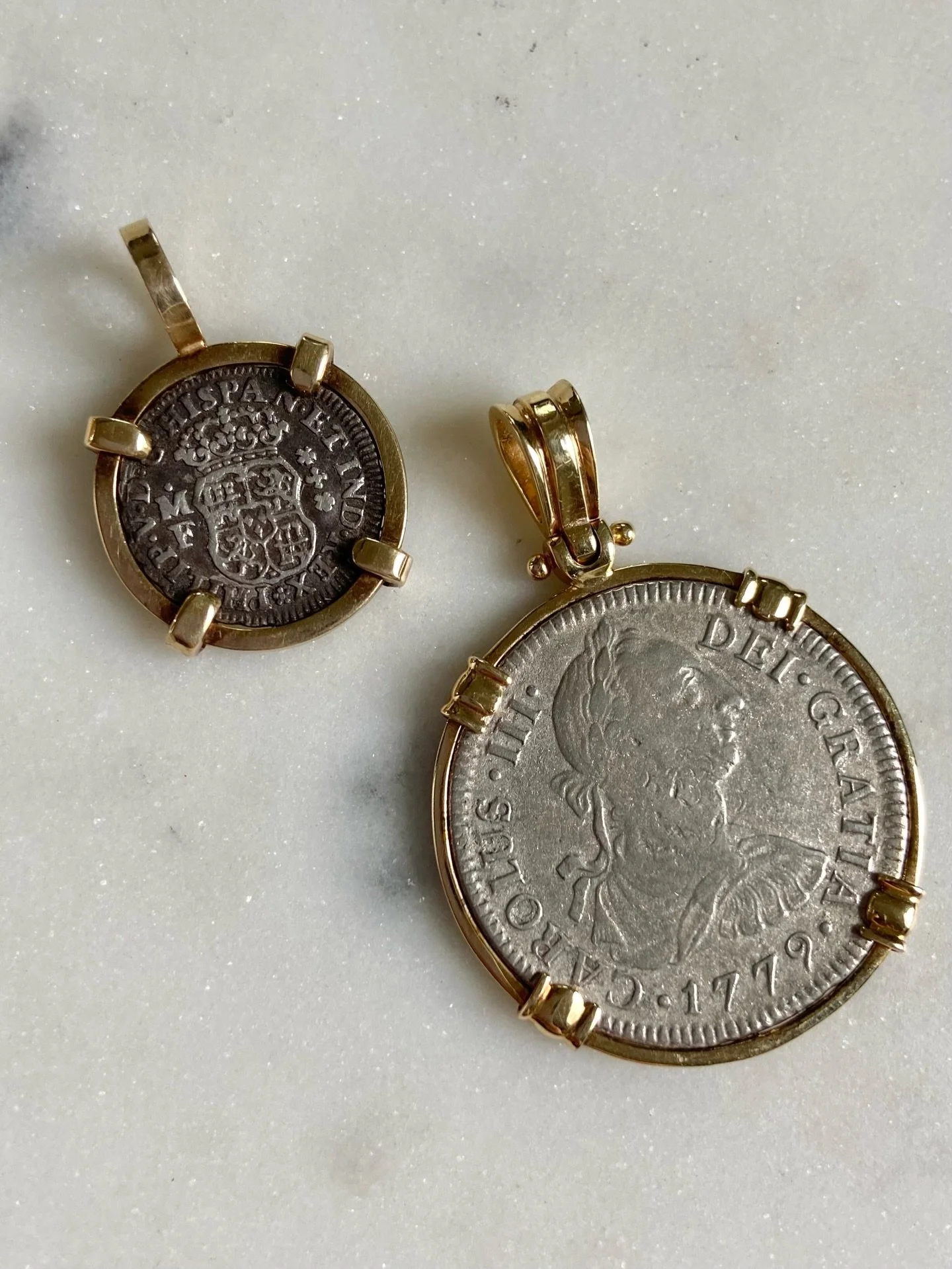 Beautiful Spanish coins from the 1700&rsquo;s both set in 14K gold! Both ship wreck era coins without paperwork to prove it, sadly! 

The larger coin is a 1779 El Cazador 2 Reales Coin (13.2g fine silver) set in a 14K gold bezel. 

The smaller of the