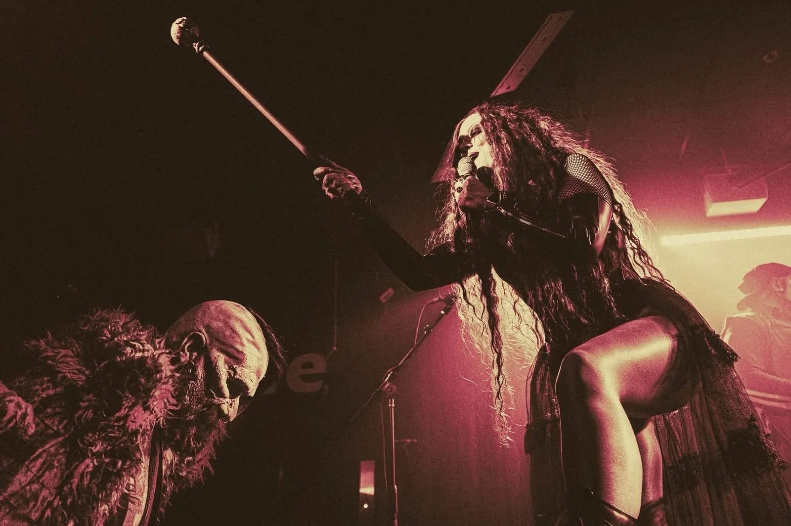 Scarah on stage placing the sword to knight a kneeling new member of Gwildor’s Army