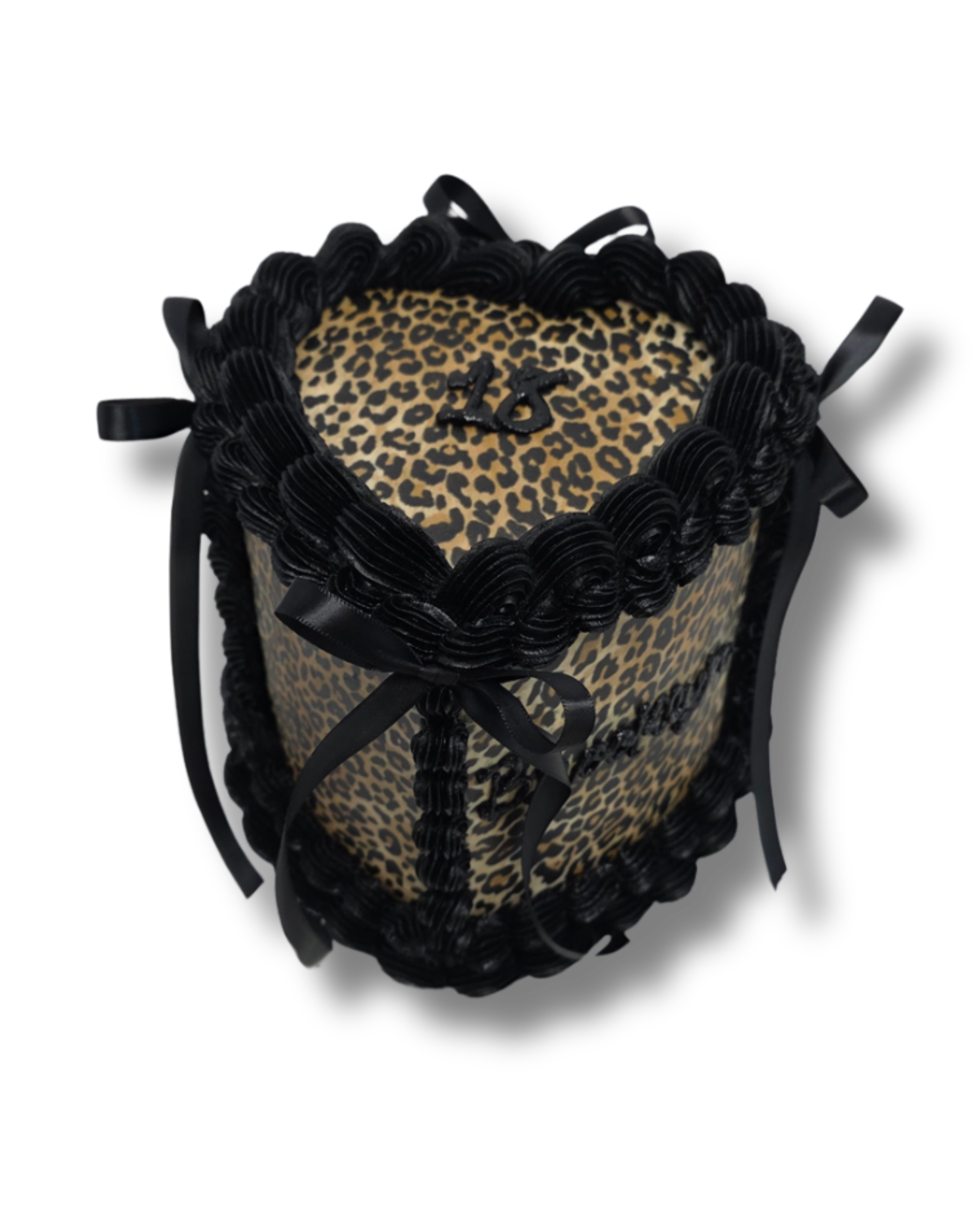 A black and leopard print birthday cake with black icing icing decorative borders, black ribbons, and the number 26 written on top of the cake.