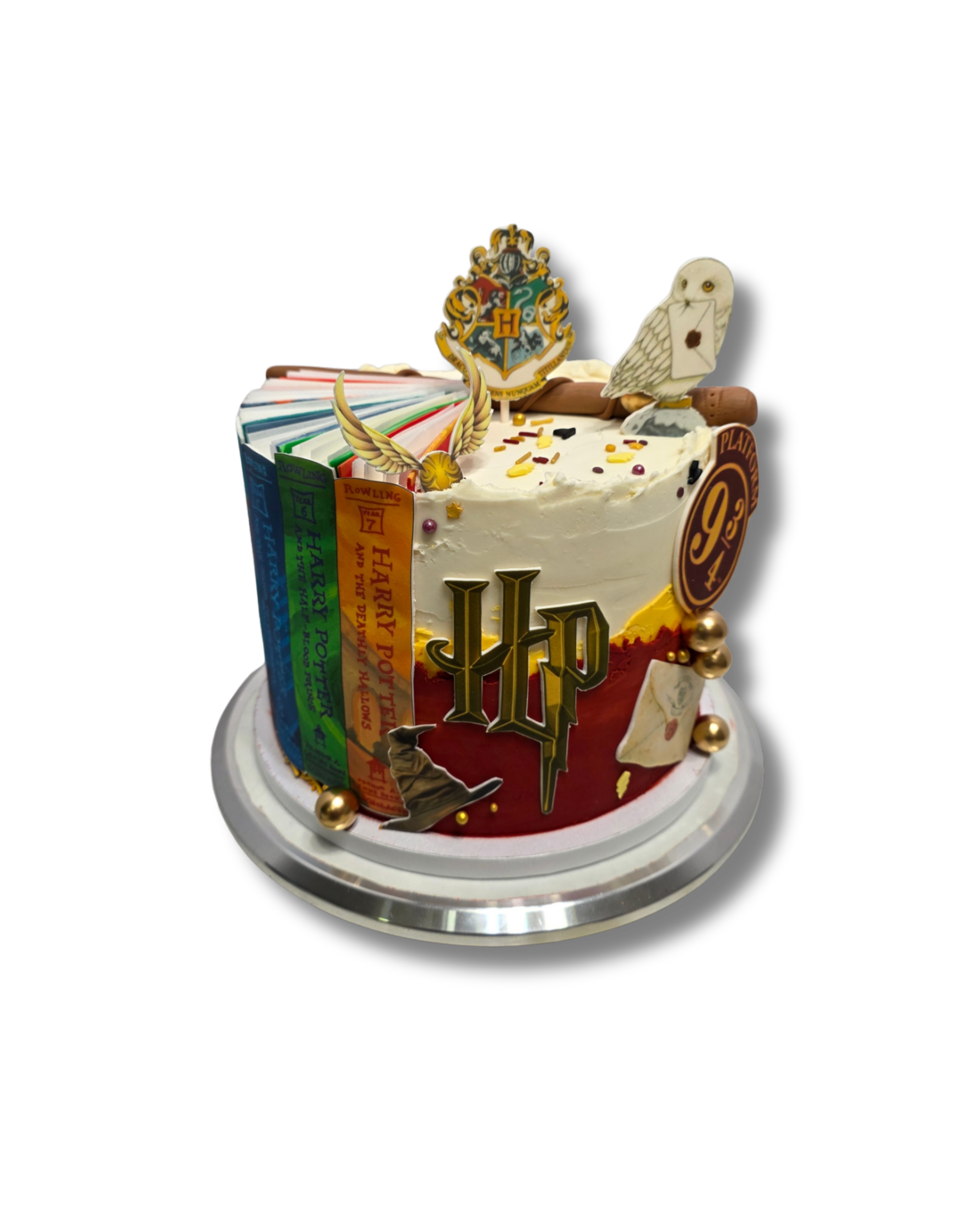 A cake decorated with Harry Potter and Harry Potter symbols, including a Hogwarts crest, a golden eagle, an owl illustration, Harry Potter's silhouette, and multicolored ribbons, set against a black background.