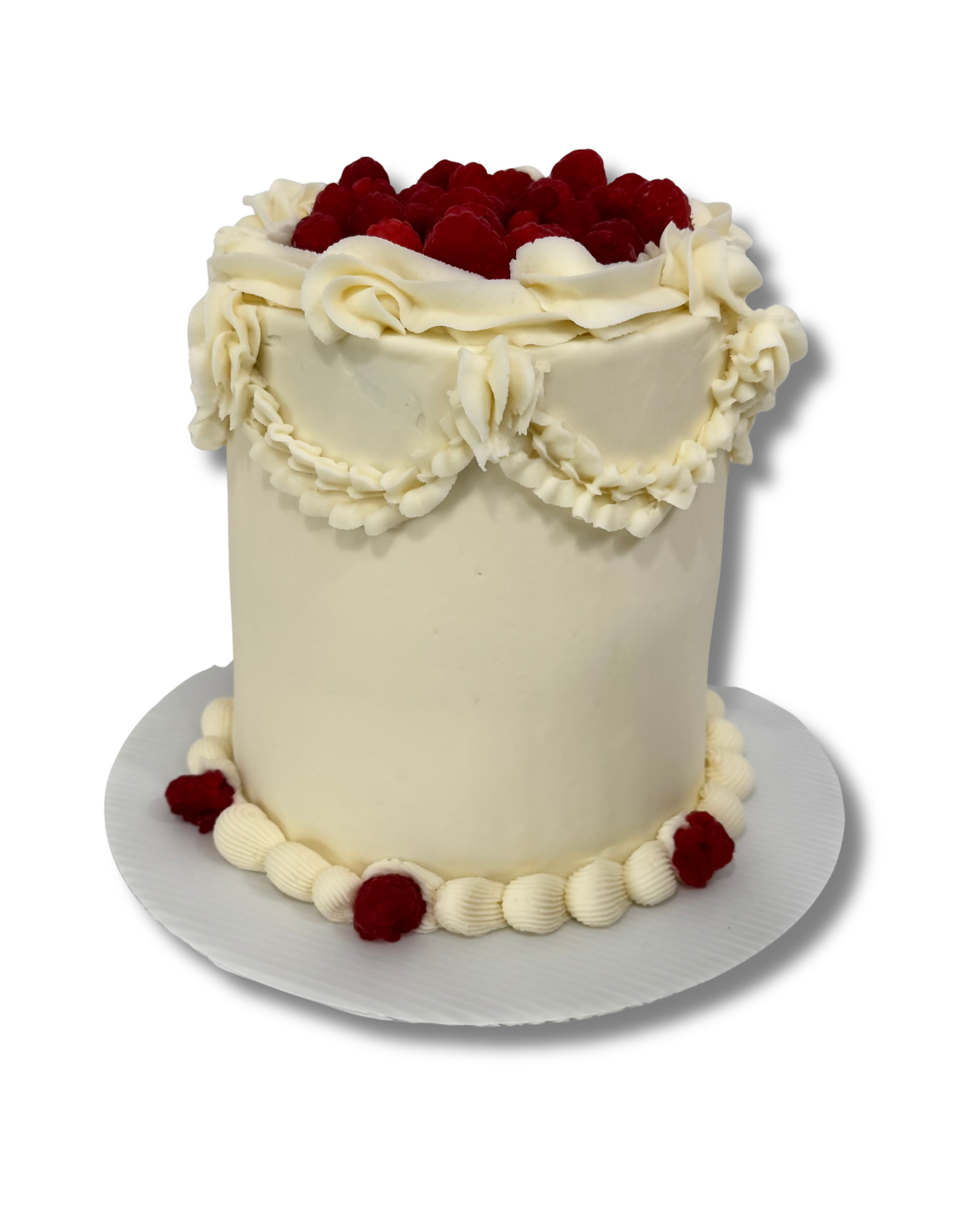 A tall white cake decorated with white frosting and raspberries on top and along the base.