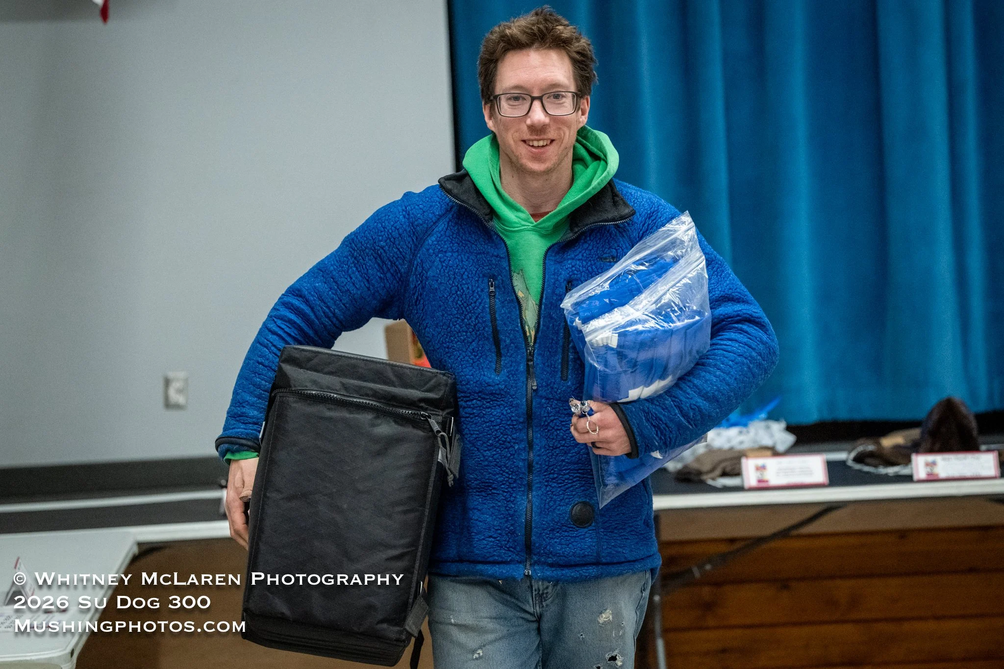 Justin Olnes takes home a sack of dog booties from Mountain Ridge and an Insulated Cooler Bag for his sled from Sled Dog Systems