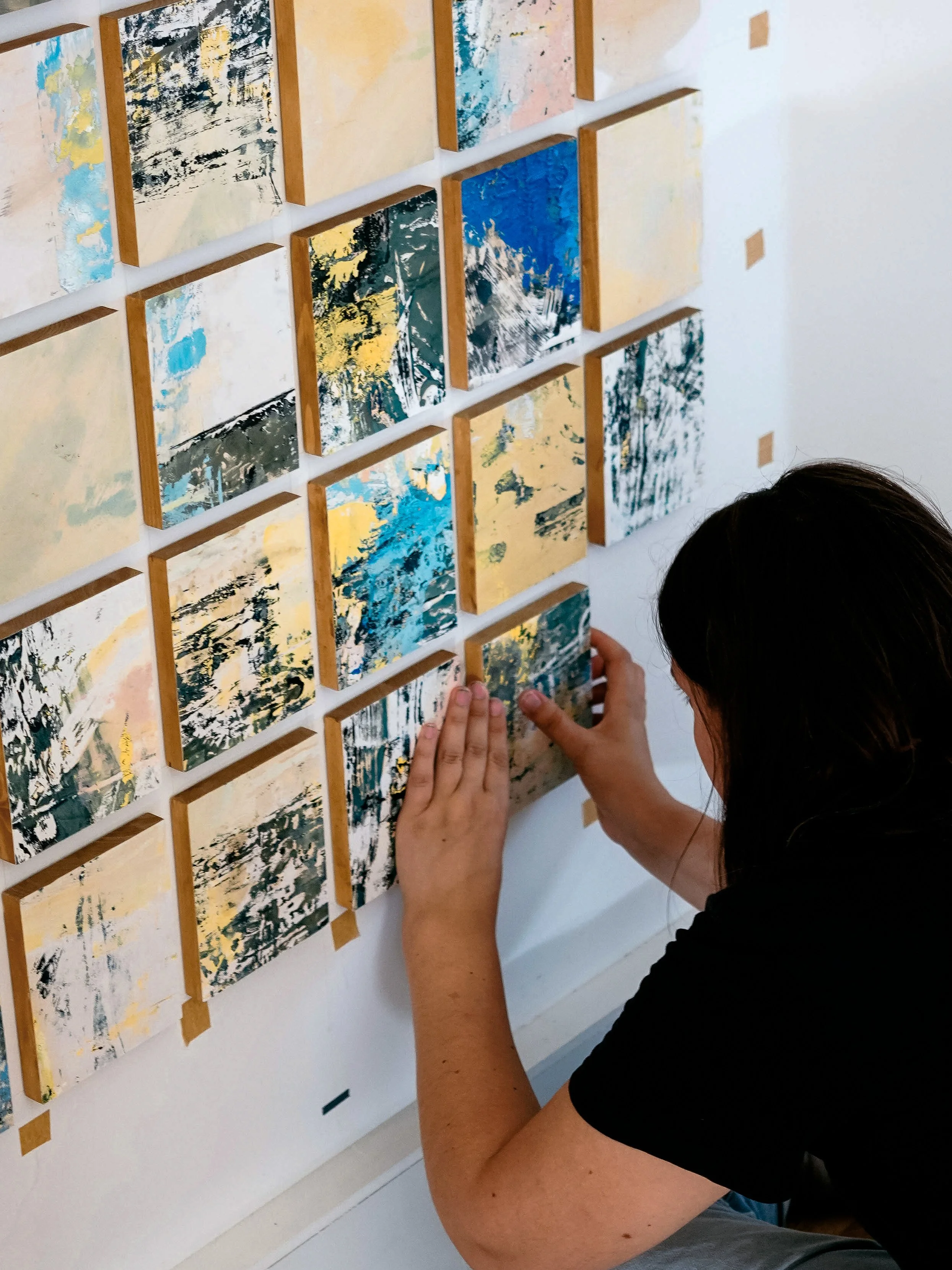 Artist installing artwork Early Recollections — An oil paint monotype mounted on oak wood