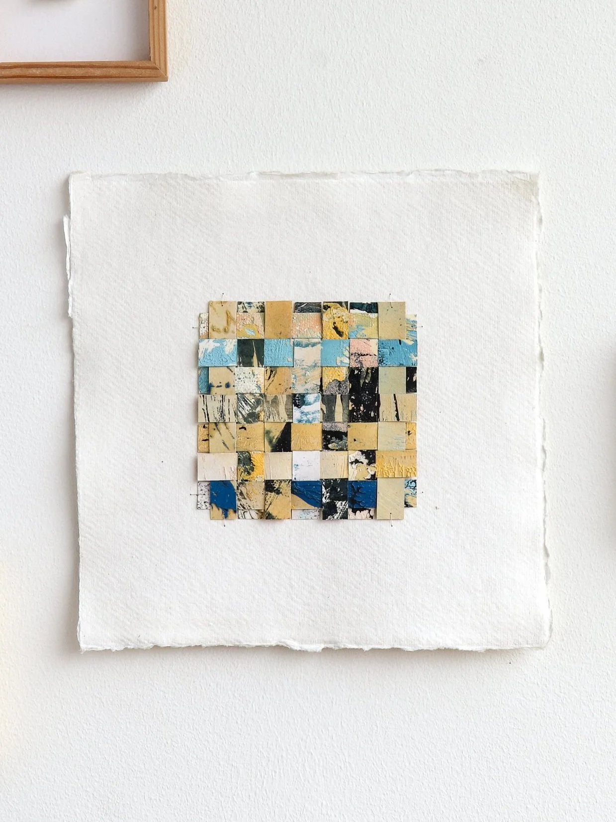 Unframed full Woven Impressions: Woven monotype artwork, with textured oil paint paper strips sewn in an interlaced pattern featuring yellow, light blue, dark blue, pink, grey, and white.