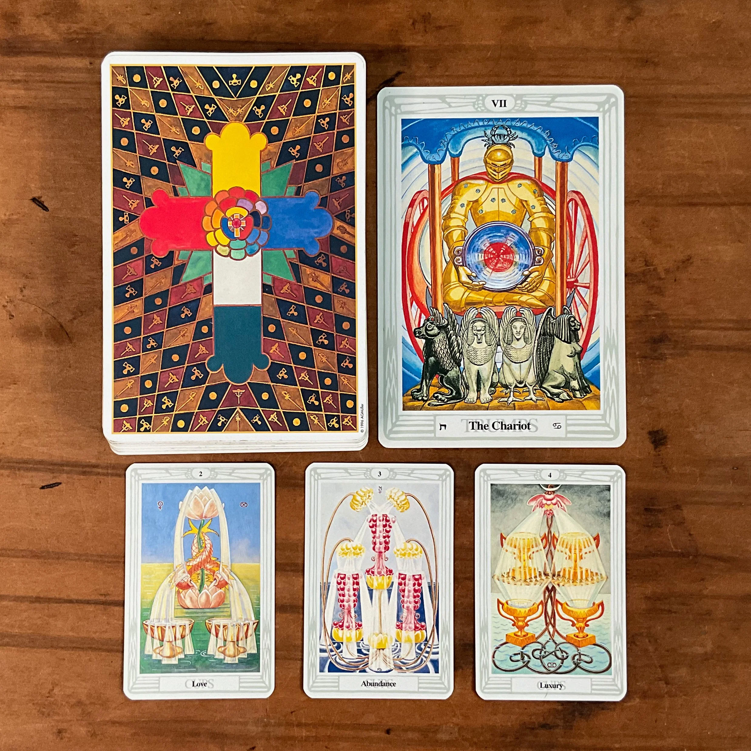 The Chariot card from Crowley's Thoth Tarot is pictured with its associated Minor Arcana cards, the 2, 3, and 4 of Cups.