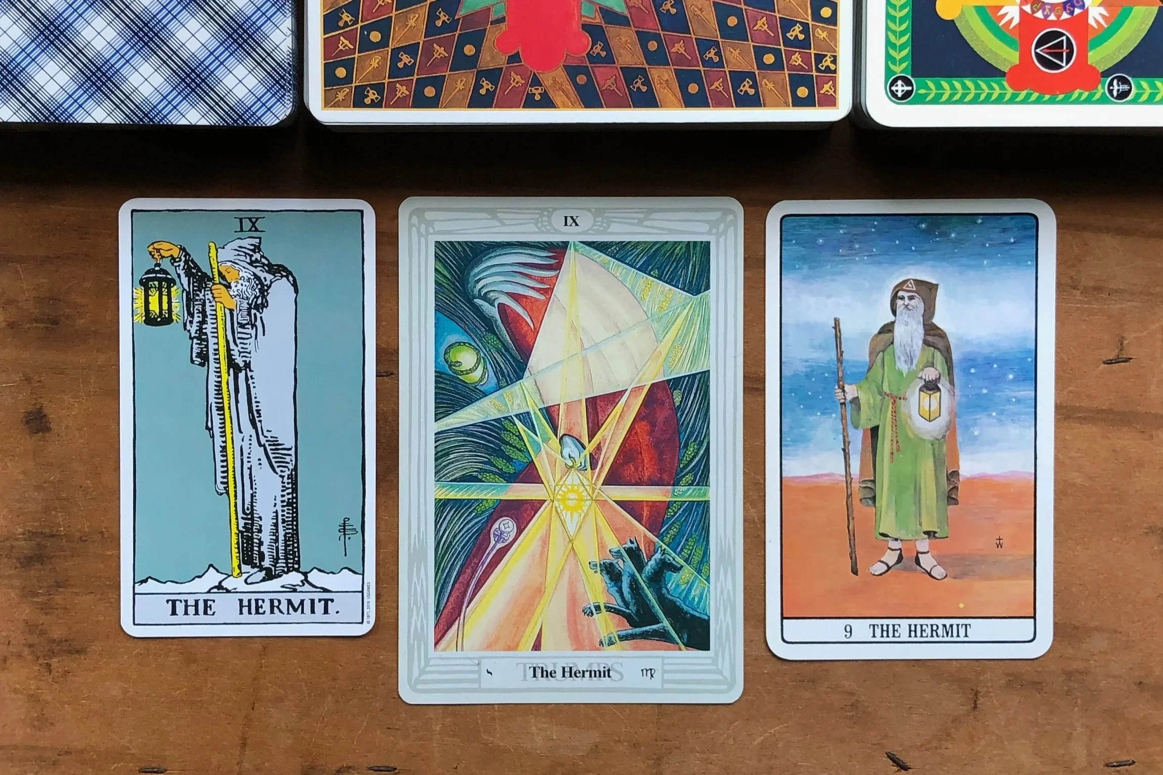 Three versions of IX. The Hermit from The Rider-Waite Tarot, Golden Dawn Tarot, and Thoth Tarot.