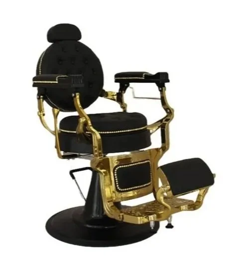 A black and gold vintage barber chair with plush cushions and intricate detailing.