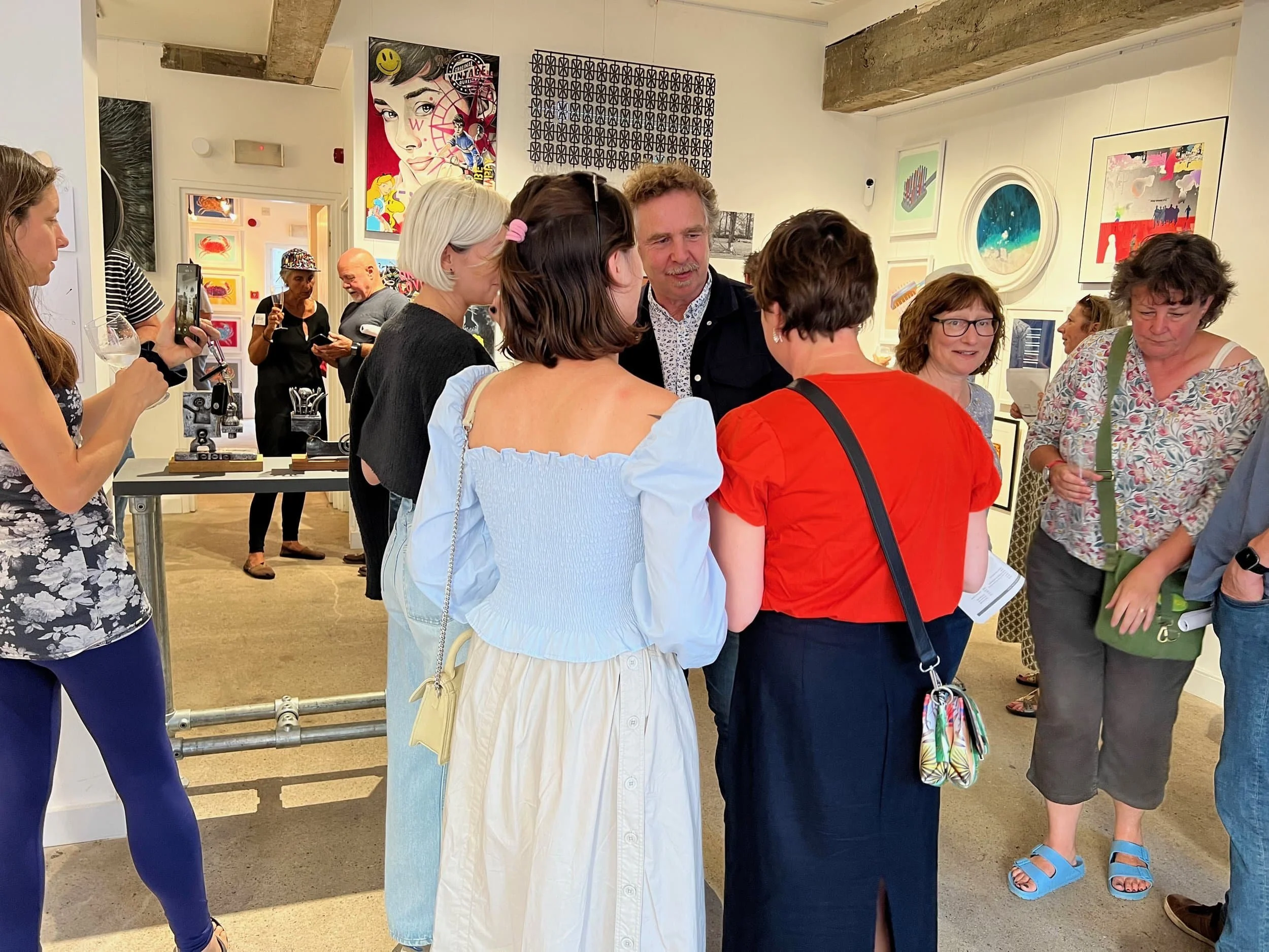 People talking and networking at an art gallery event