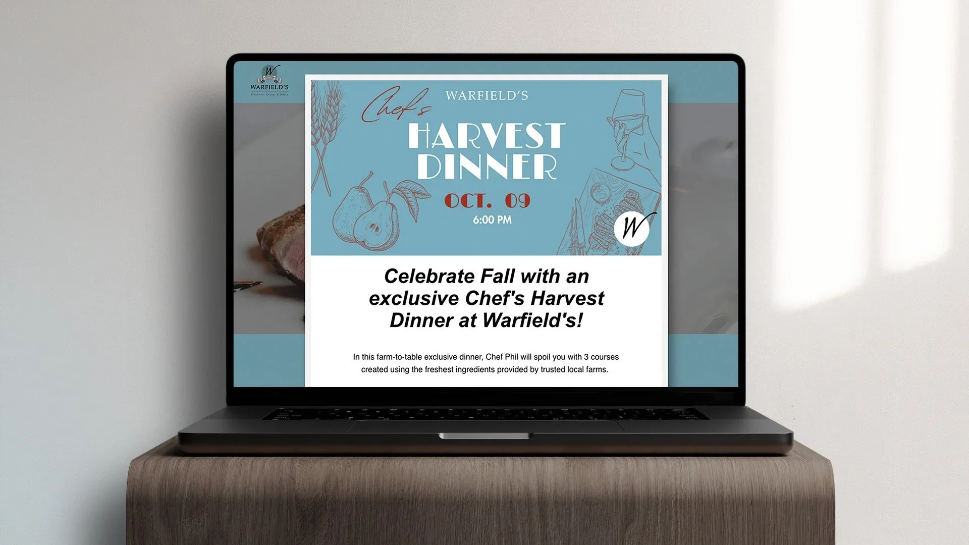 Laptop on wooden table displaying an advertisement for Warfield's Chef's Harvest Dinner event scheduled for October 9th at 6:00 PM, with fall-themed graphics and event details.