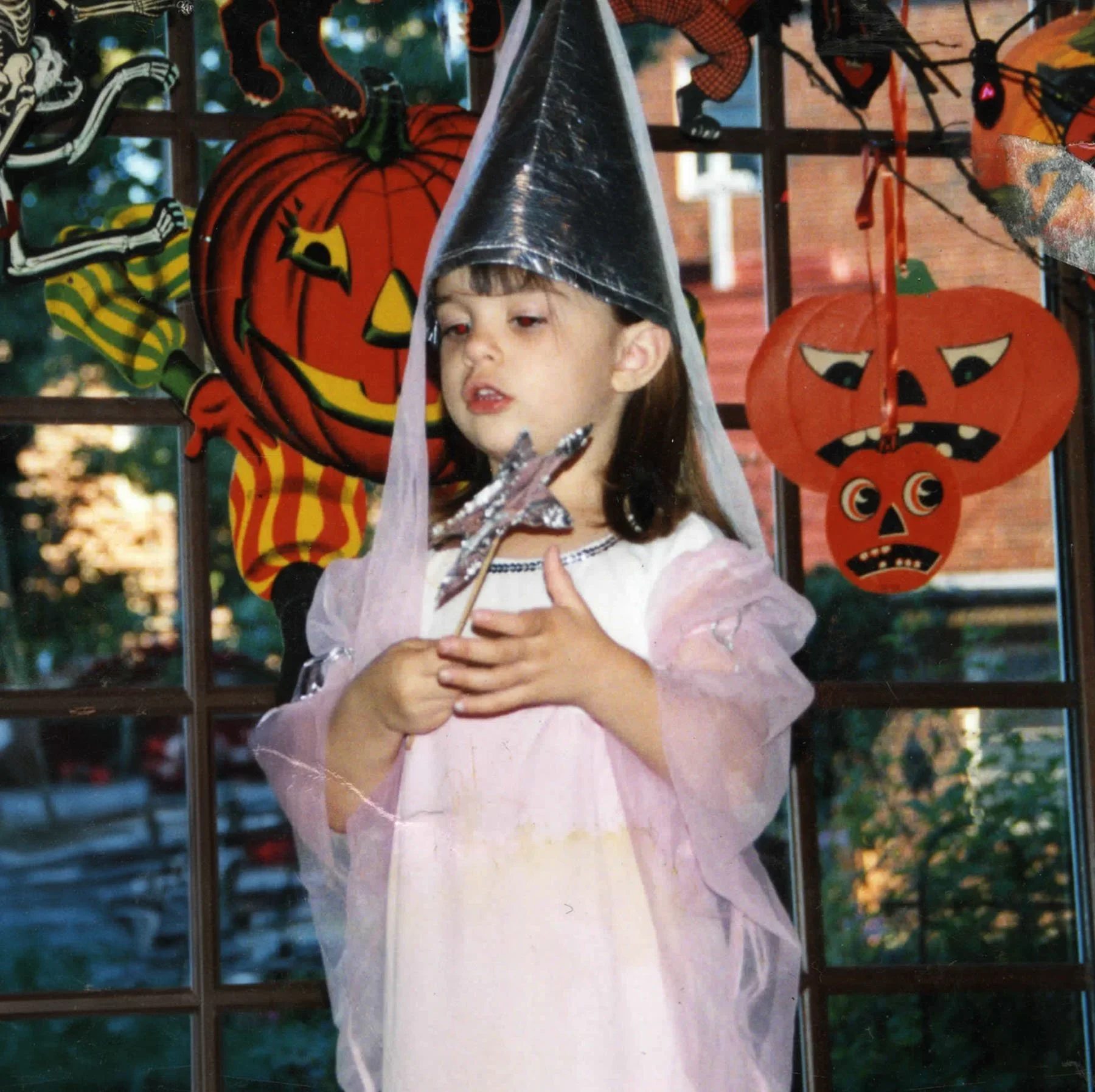 Delila Miske as a child dressed in a fairy costume holding a star wand at a Halloween party.