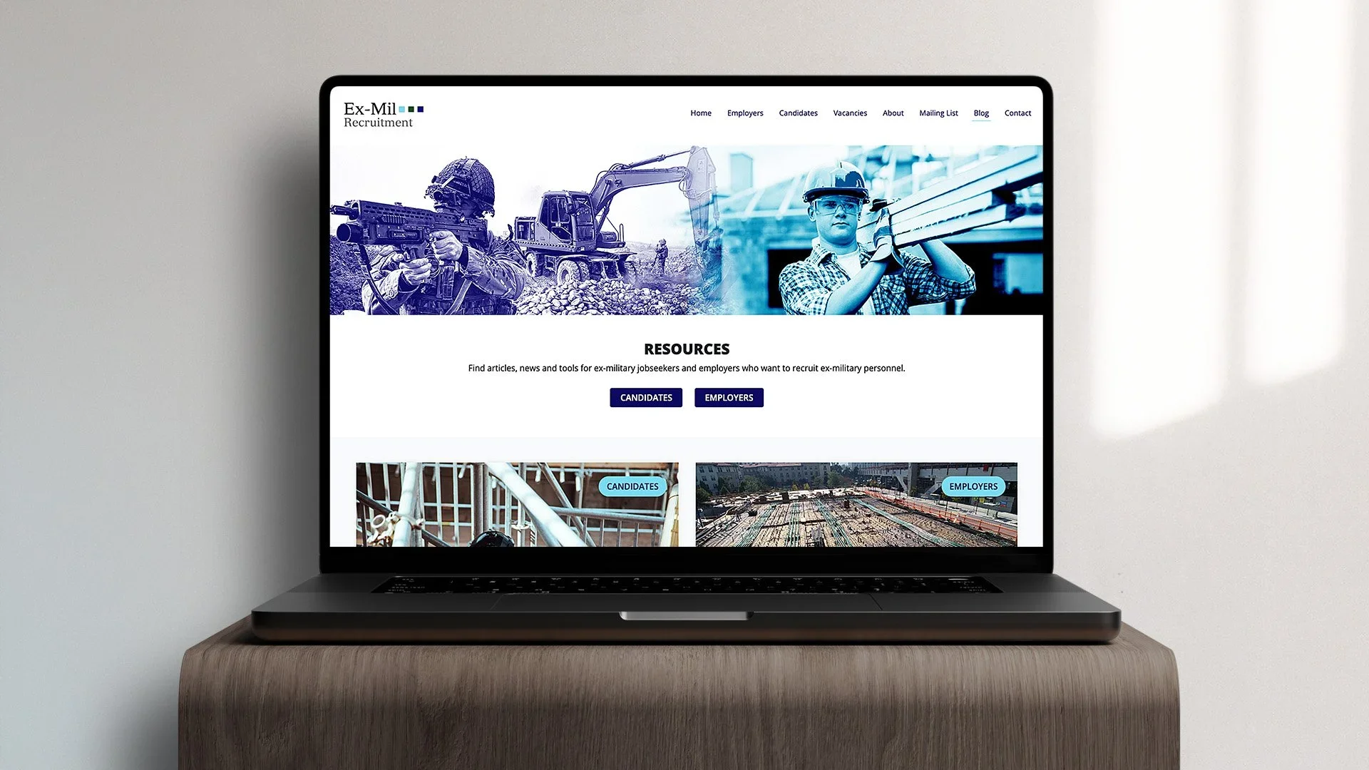 Laptop on a wooden desk displaying a website for ex-military recruitment, featuring images of military personnel and construction workers, with navigation links and resource buttons.