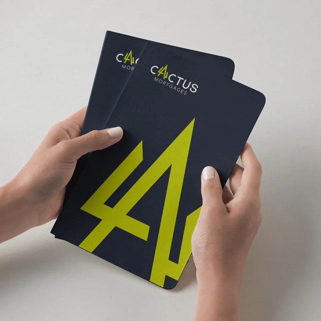 hands holding cactus mortgages logo notebooks designed by saia creative