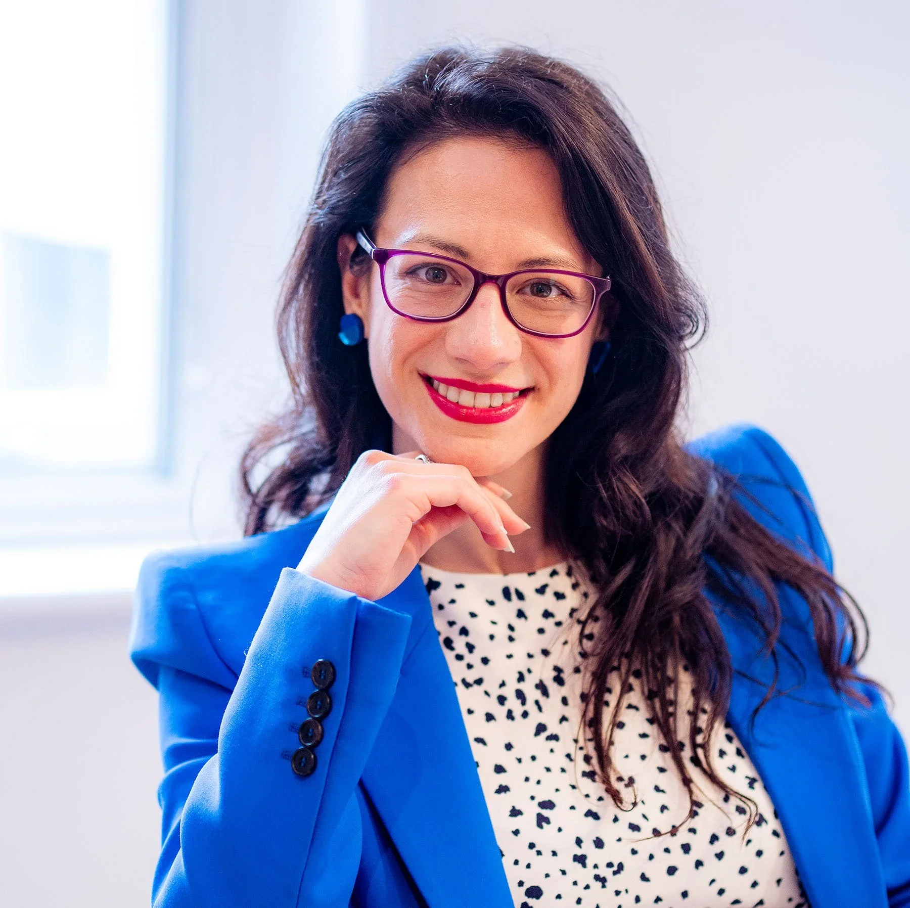Rosie Di Lecce in a bright blue blazer smiling in a professional portrait.