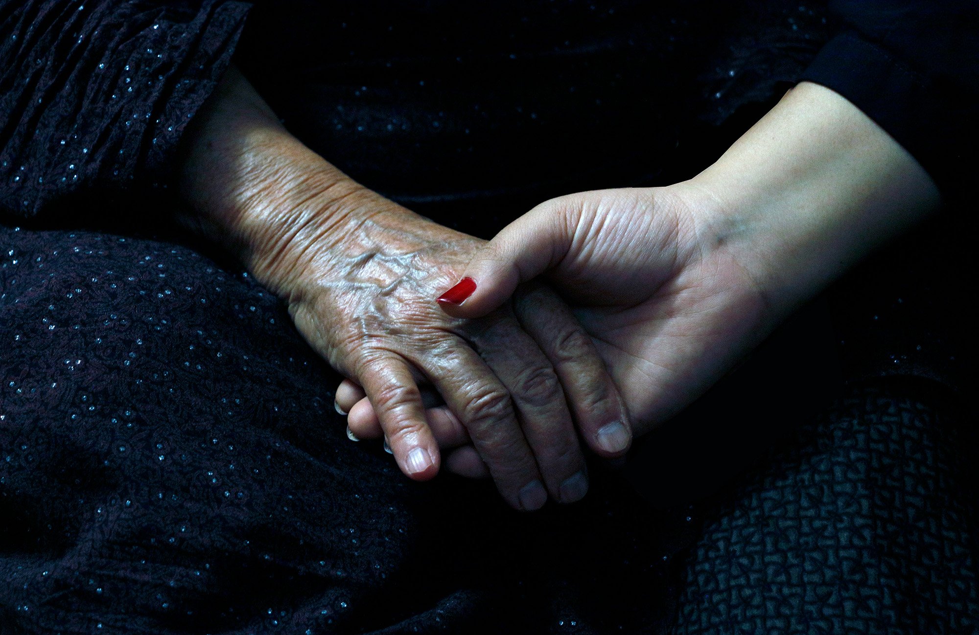 Young hand holding an older hand - showing companionship
